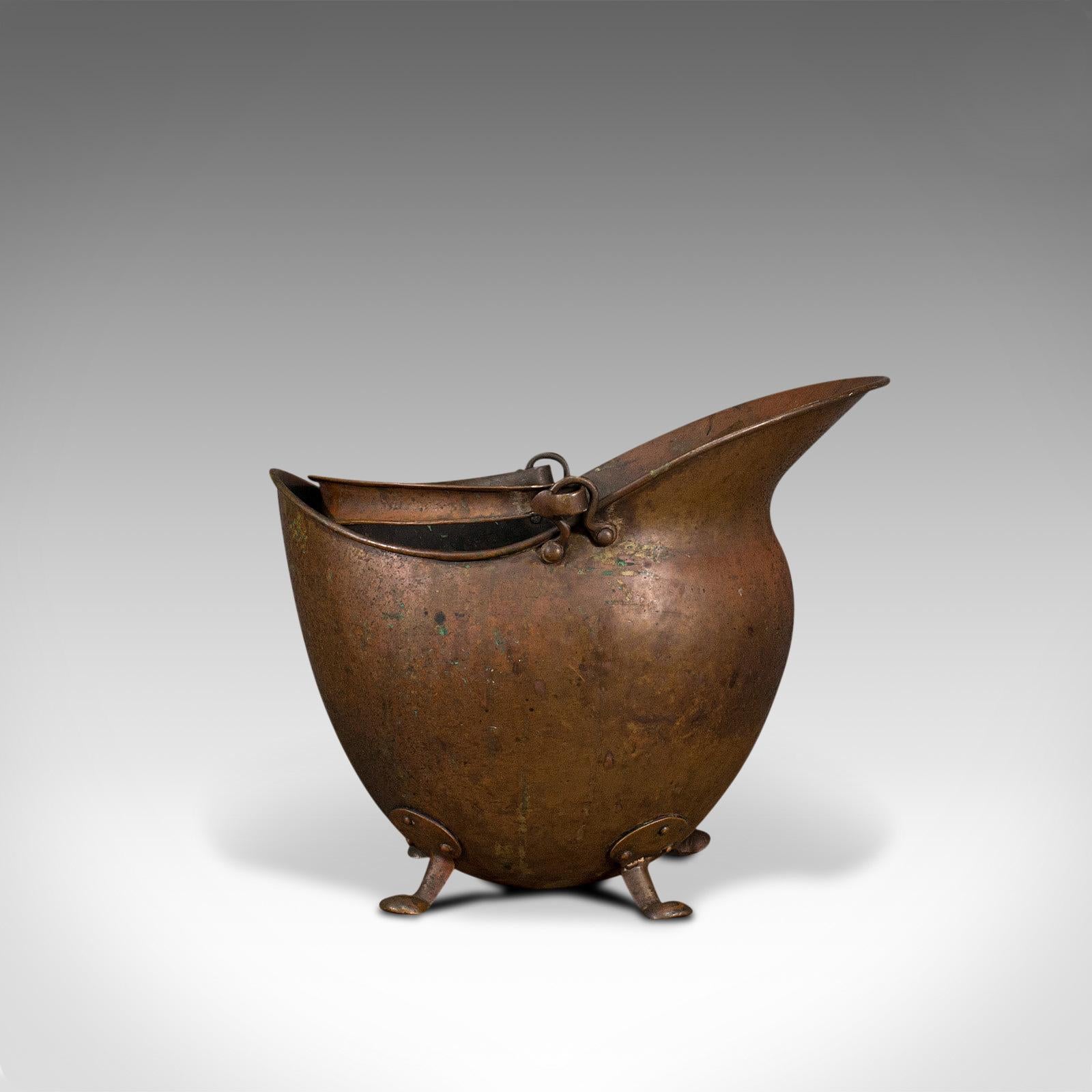 Il s'agit d'un scuttle de casque antique. Un panier à charbon anglais en cuivre pour la cheminée, datant de la période victorienne, vers 1880.

Magnifique patine de la forme globulaire
Affichant une patine vieillie souhaitable et un