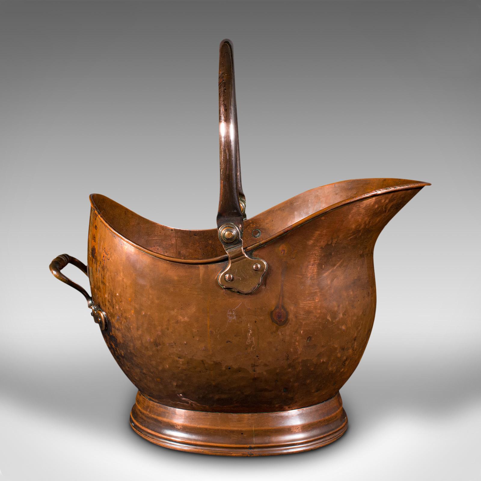 This is an antique helmet scuttle. An English, copper coal bucket or fireside bin, dating to the early Victorian period, circa 1850.

Delightful helmet shaped scuttle with wonderful warm hues
Displays a desirable aged patina and in good original