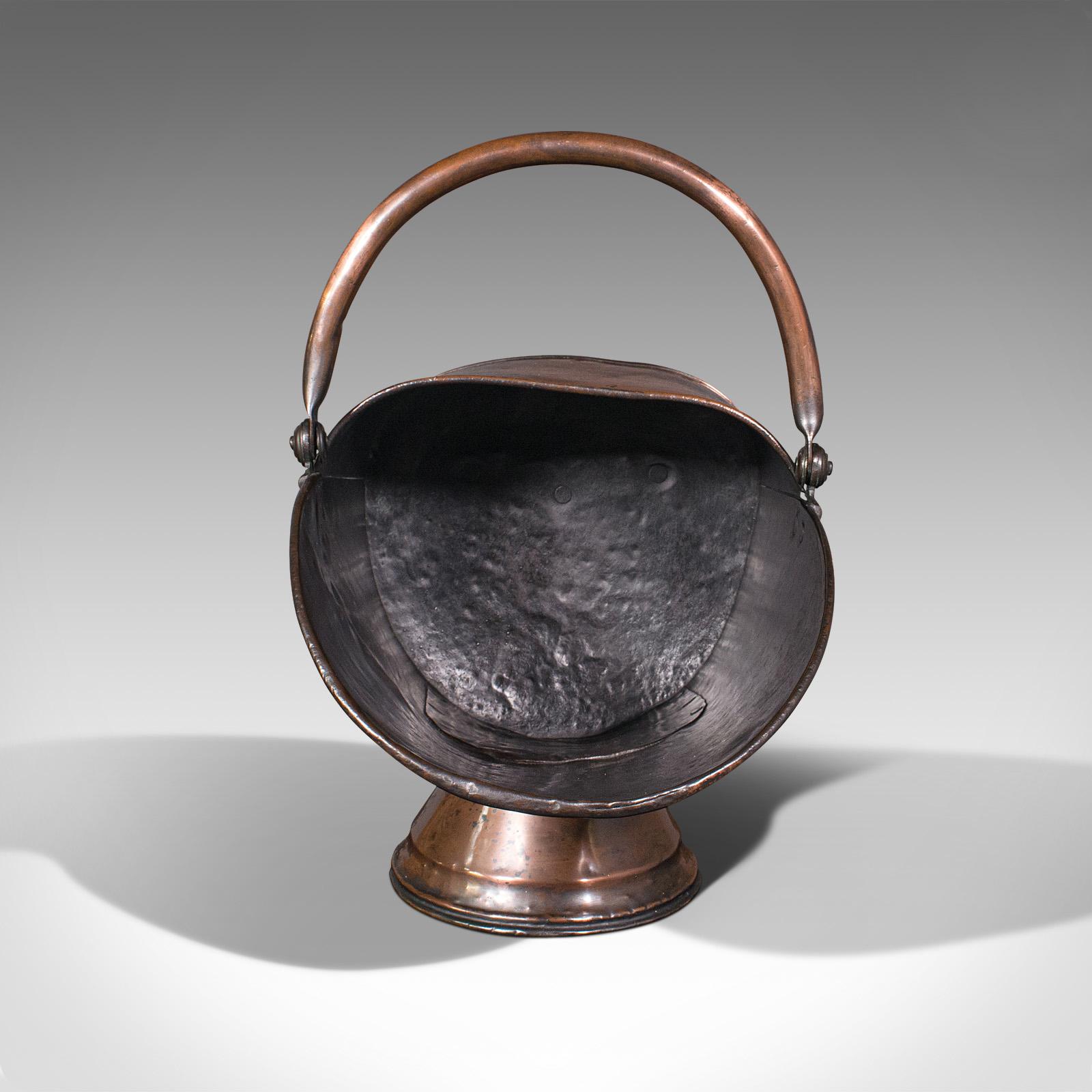 This is an antique helmet scuttle. An English, copper fireside coal or log bucket, dating to the early Victorian period, circa 1850.

Hand-beaten, eye-catching and delightfully patinated scuttle
Displays a desirable aged patina throughout
Copper