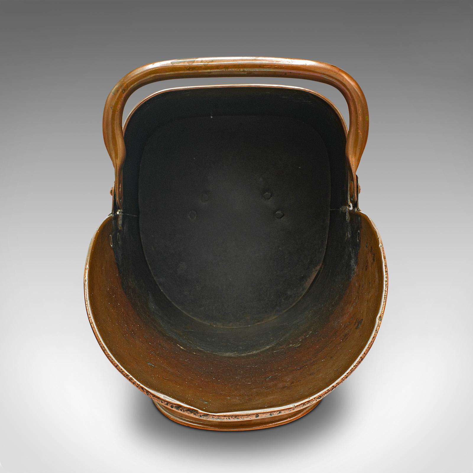This is an antique helmet scuttle. An English, copper fireside coal or log bucket, dating to the late Victorian period, circa 1900.

Attractive fireside helmet scuttle with great finish
Displays a desirable aged patina throughout
Delightfully