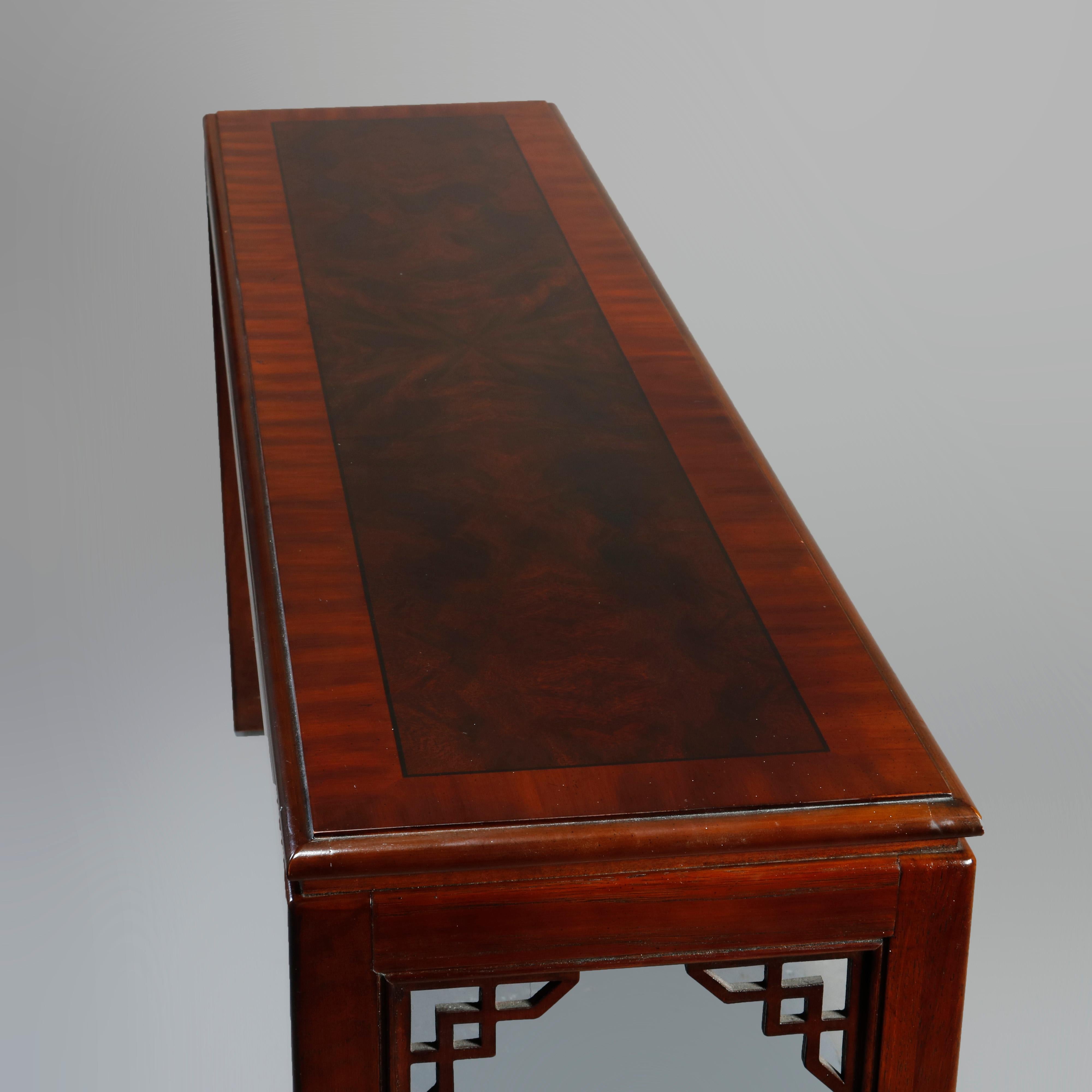 An antique Chinese Chippendale long console table by Drexel offers mahogany and burl crossbanded top with ebonized trimming over base with cutout corbels and raised on straight and square legs, 20th century

Measures: 27
