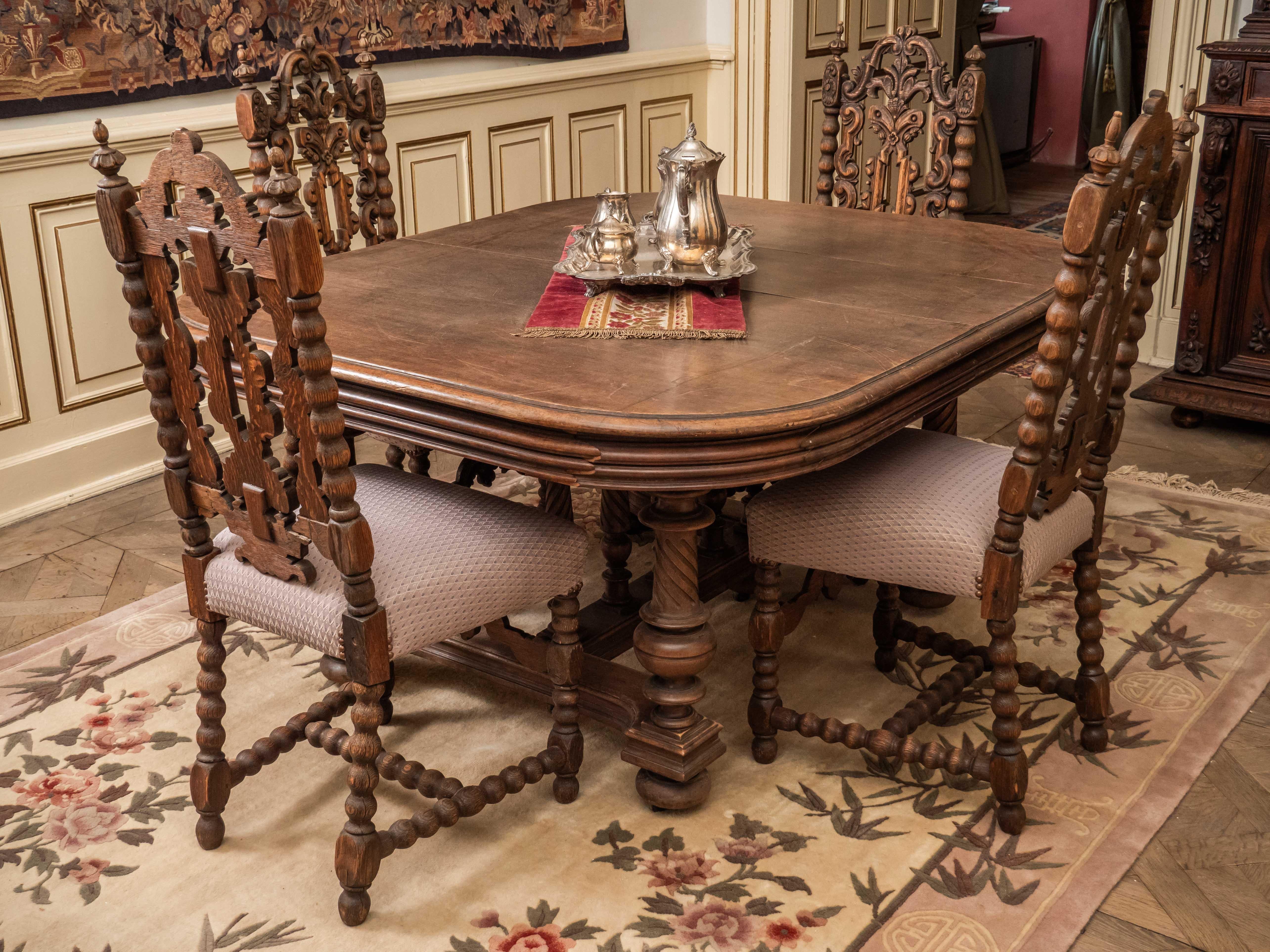 Dining table made of solid walnut in the Renaissance style of Henry II. The table has a richly turned base with oblique channeling. The central crucifix is ​​with a balustrade. The entire table is on wheels, which are hidden under the spherical