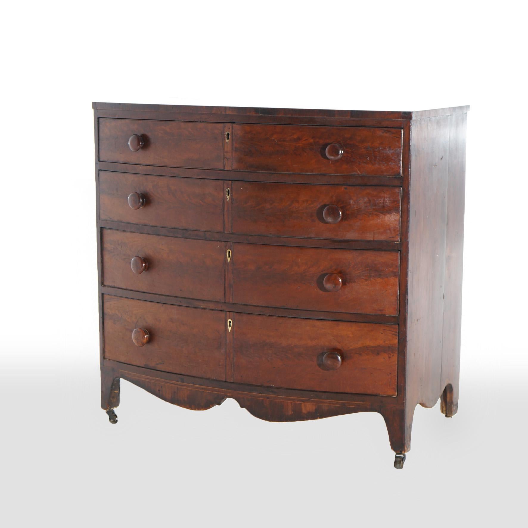 An antique English Hepplewhite chest offers flame mahogany construction in bow-front form with four graduated long drawers over shaped skirt and raised on splayed legs, c1830

Measures - 38.75