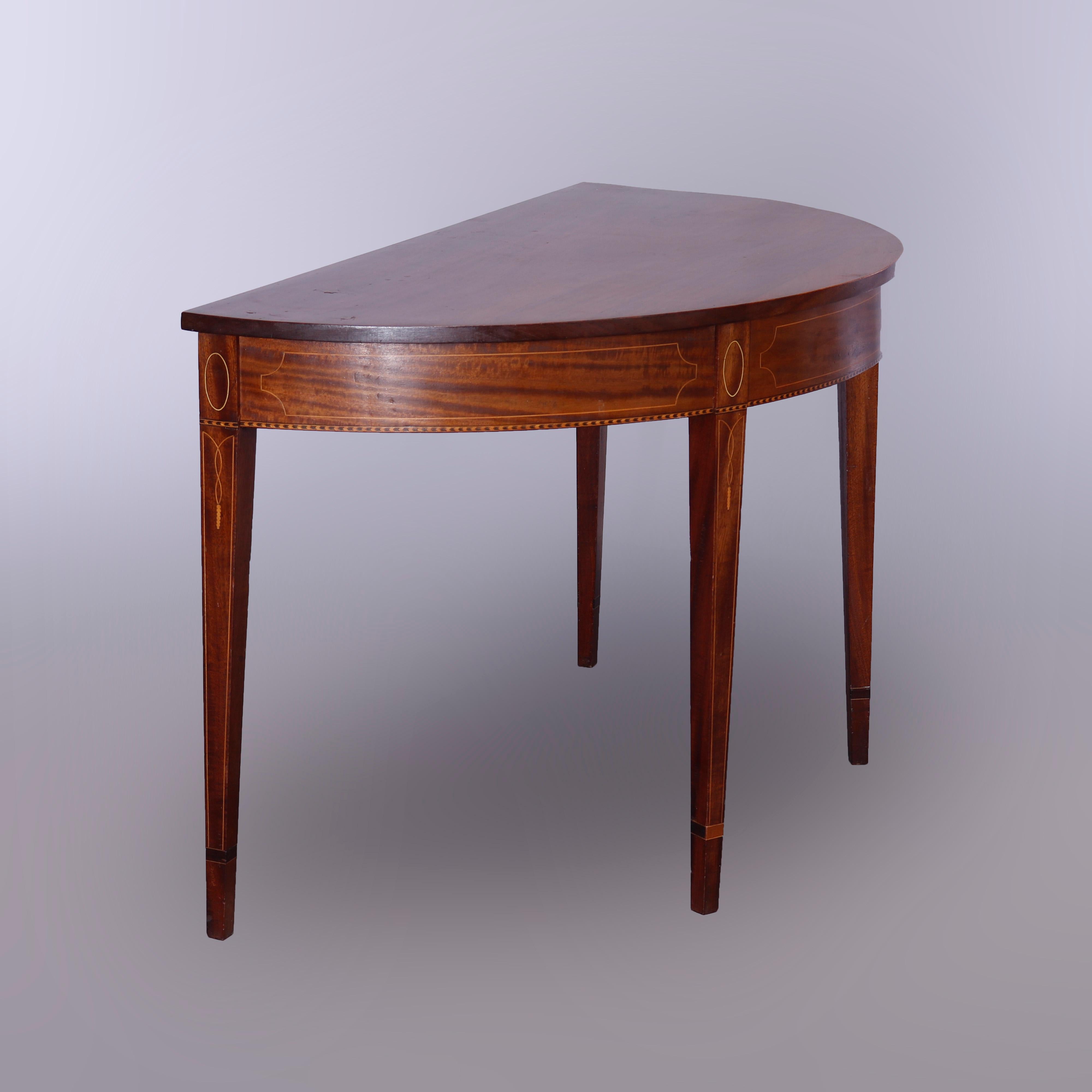 An antique Hepplewhite banquet dining table offers flame mahogany construction with satinwood inlaid decoration throughout and includes two demilune sections and one drop leaf section, each raised on square and tapered legs, 19th century

Measures