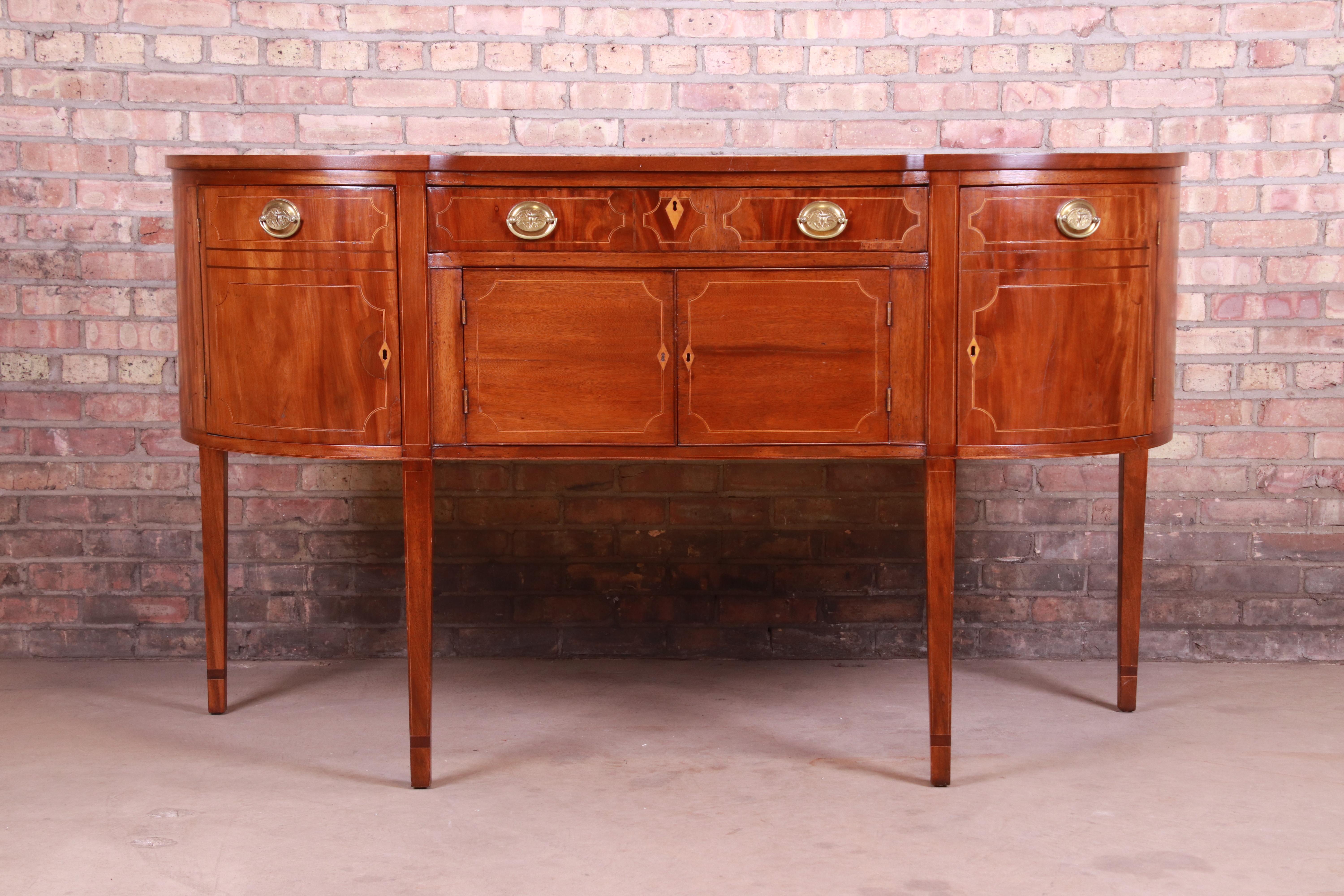 A gorgeous antique Hepplewhite demilune sideboard or credenza,

circa 1800

Mahogany, with satinwood inlay and original brass hardware.

Measures: 68.38