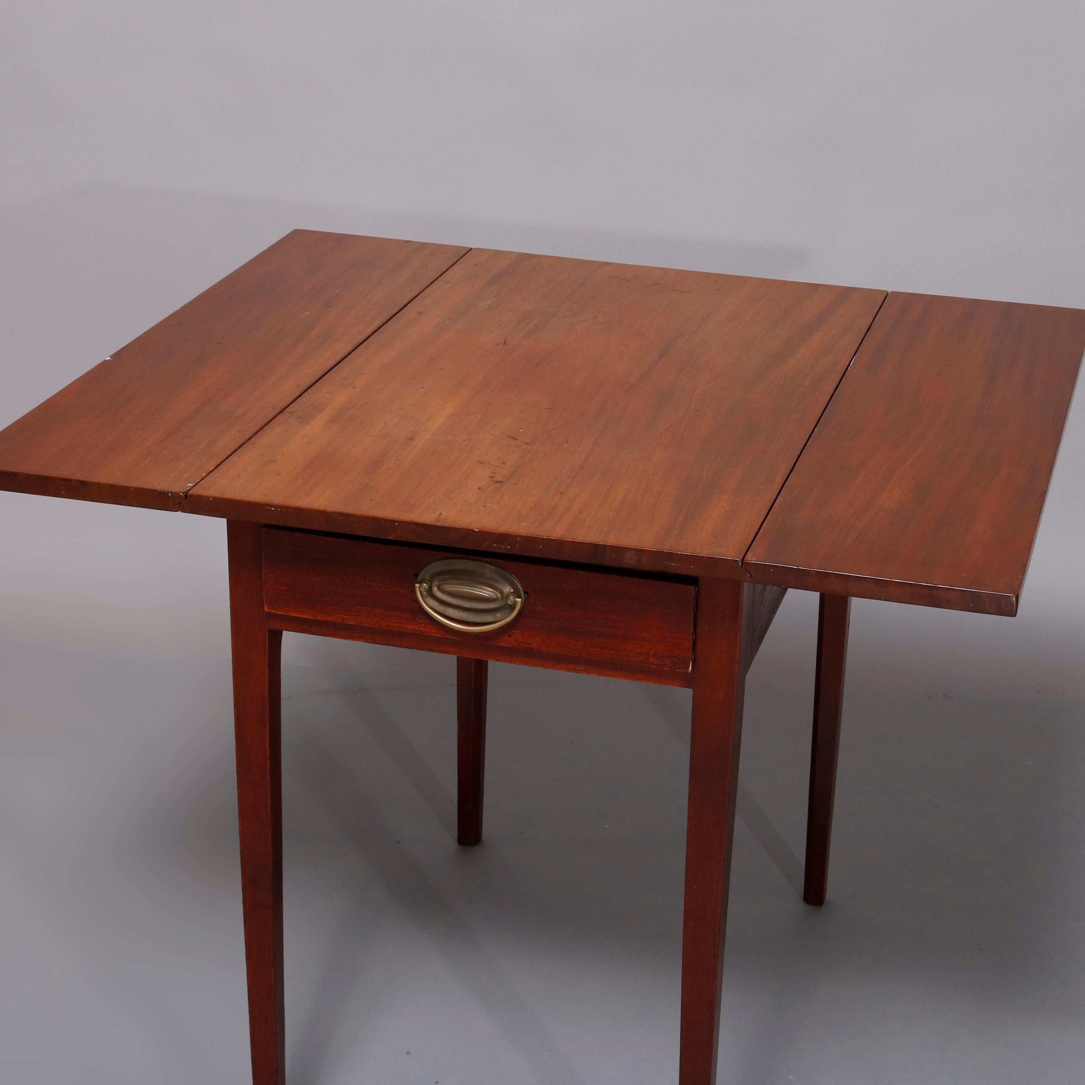 An antique Hepplewhite style pembroke side stand offers mahogany construction with single drawer case having drop leaves and cast bronze pull, raised on square and tapered legs, circa 1830

***DELIVERY NOTICE – Due to COVID-19 we have employed