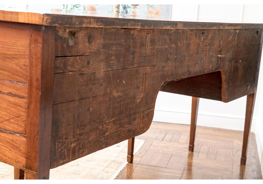 A quality antique mahogany sideboard with unusual features. The case with an angular projecting bow front and long center frieze drawer. One side with a deep drawer and the other side with a door opening to storage and a drawer at the top with brass