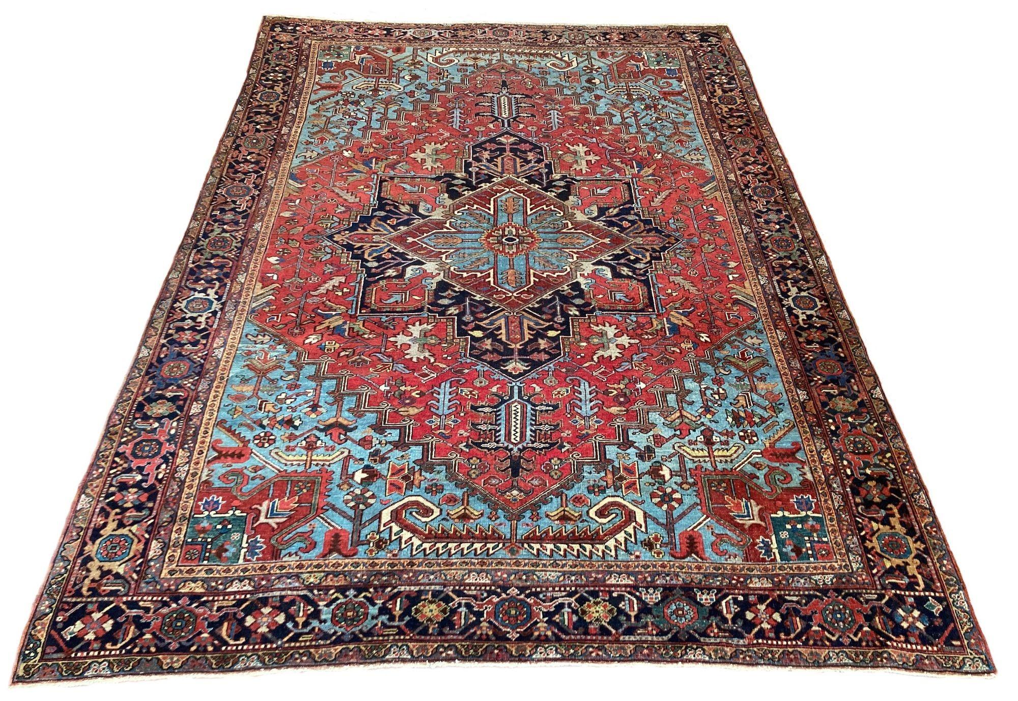 A fabulous antique Heriz carpet, hand woven circa 1920. The design features a large geometrical medallion on a raspberry red field and deep indigo border. Lovely secondary colours, especially the large, light blue corner spandrels.
Size: 3.96m x