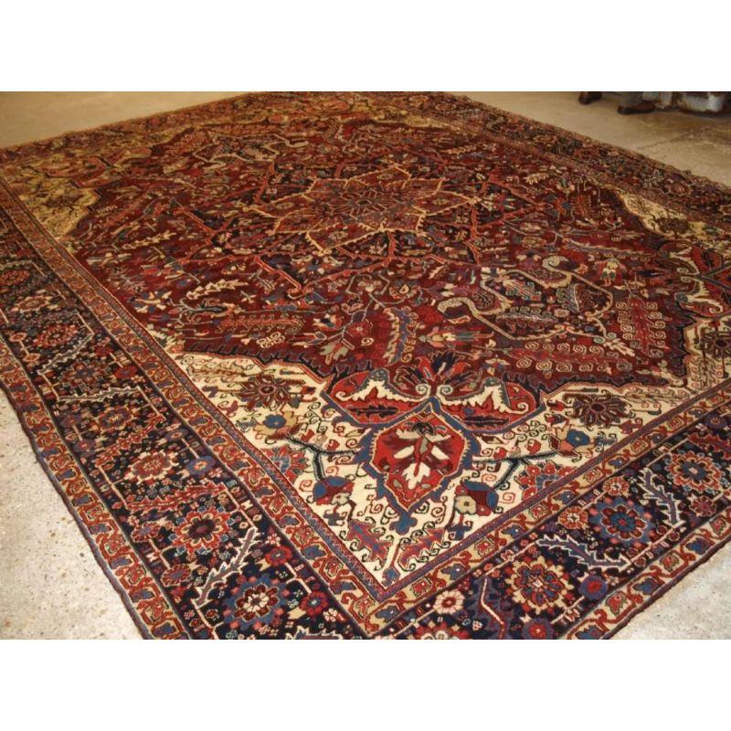 Antique Persian Heriz carpet with a traditional medallion design in a deep plum red field colour and classic dark indigo blue border that is very well drawn. The carpet is a substantial large size.

The Carpet is in excellent condition with very