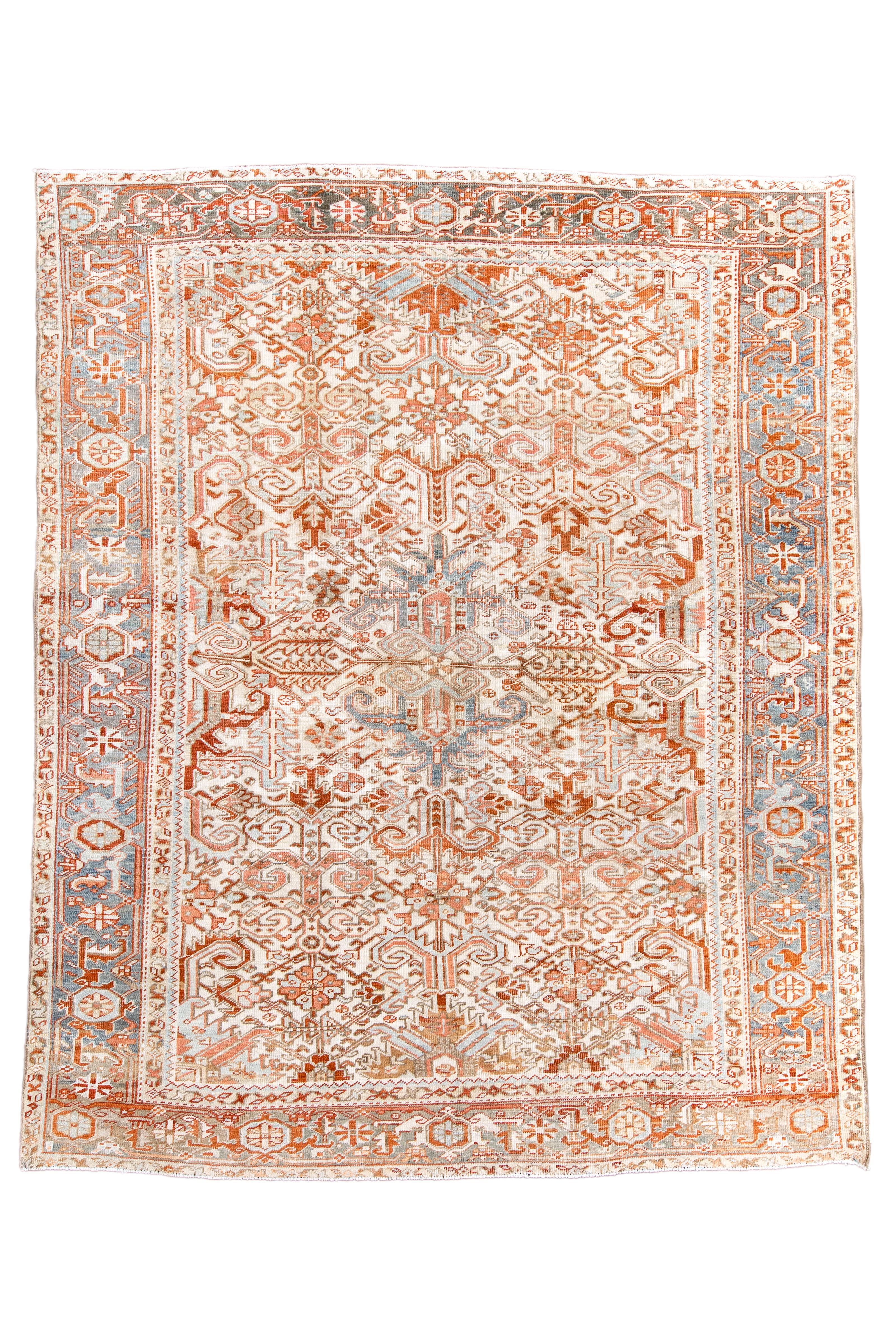 This piece features a cream field that is fully and closely filled with rosettes, voluted rams’ horns and hooked diagonals, centred by a teal blue voluted, openwork medallion. There are rust details throughout and a teal strip style reversing