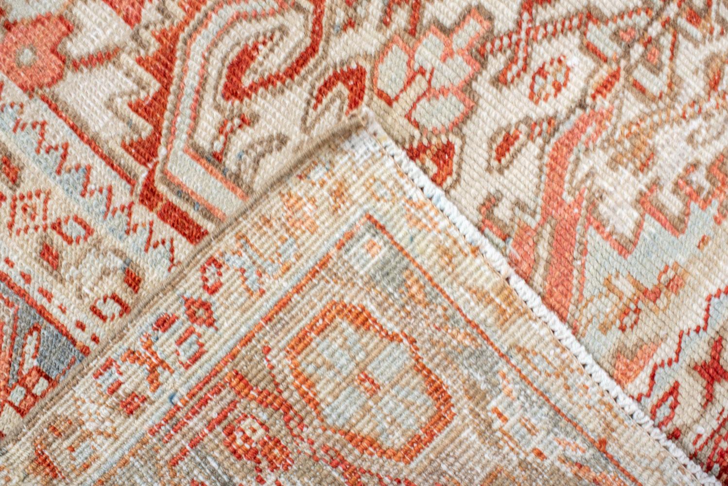 20th Century Antique Heriz Carpet Featuring an Array of Rosettes and an Open Medallion For Sale