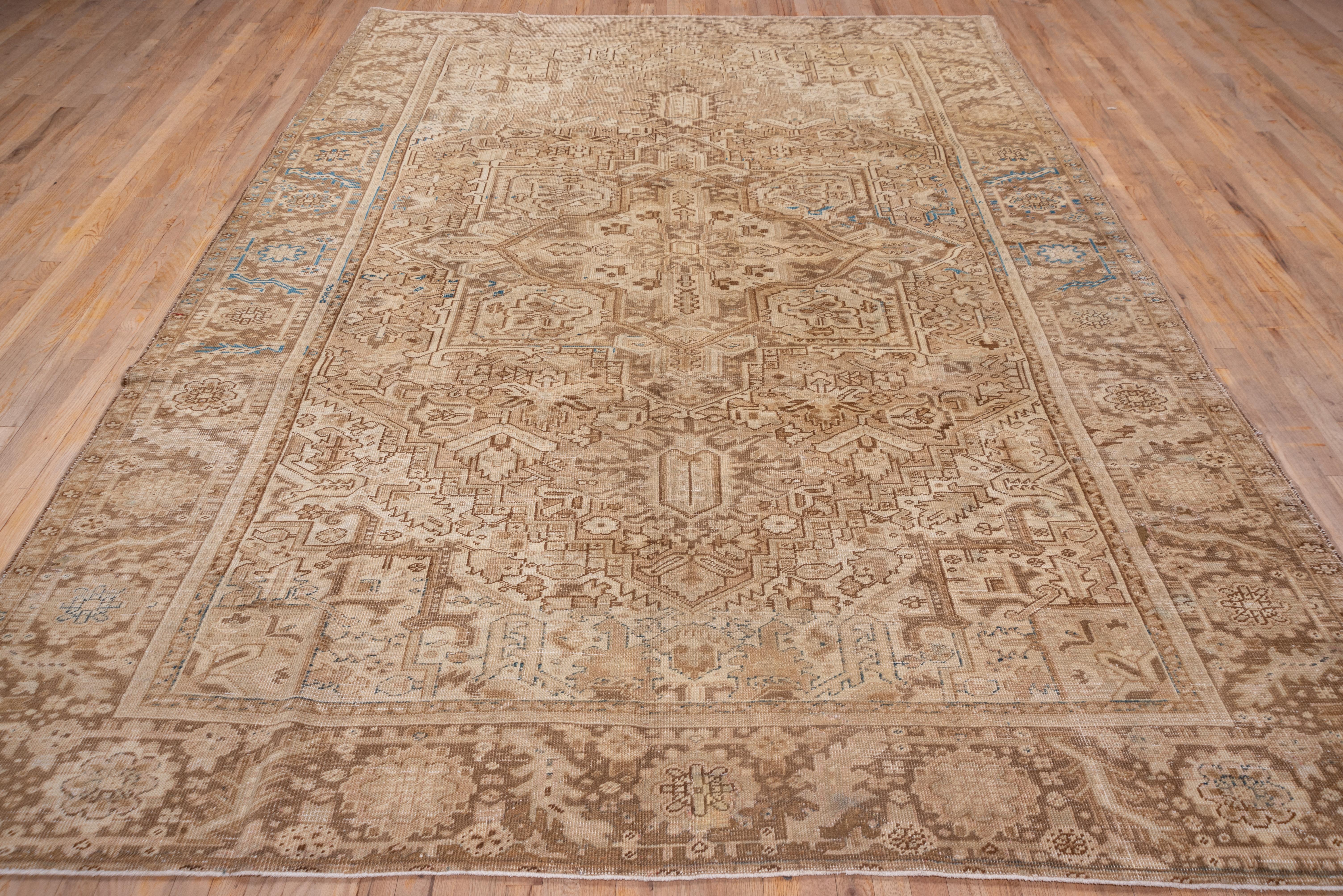 This lightly toned rustic NW Persian carpet features a palette of browns, buffs, cream and beige's, with a central octogramme medallion and cream triangular corners. The geometric drawing extends to the sienna brown border with a bent leaf and