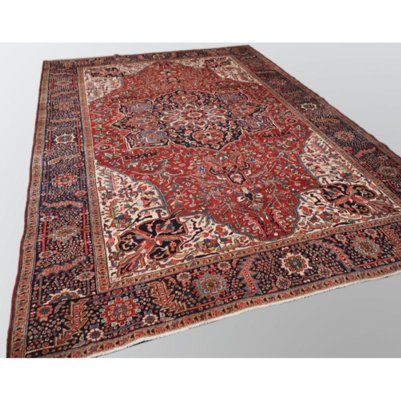 Antiker persischer Heriz-Teppich mit traditionellem Medaillon-Muster, weiche krapprote Feldfarbe mit elfenbeinfarbenen Zwickeln Klassische dunkelindigoblaue Bordüre, die sehr gut gezeichnet ist Das zentrale Medaillon in dunklem Indigoblau