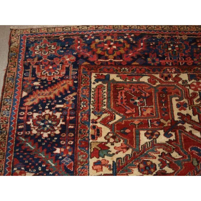Antique Persian Heriz carpet with a traditional medallion design and clear madder red field colour with a classic dark indigo blue border that is very well drawn. The large central medallion in dark indigo blue contrasts well with the field.

The