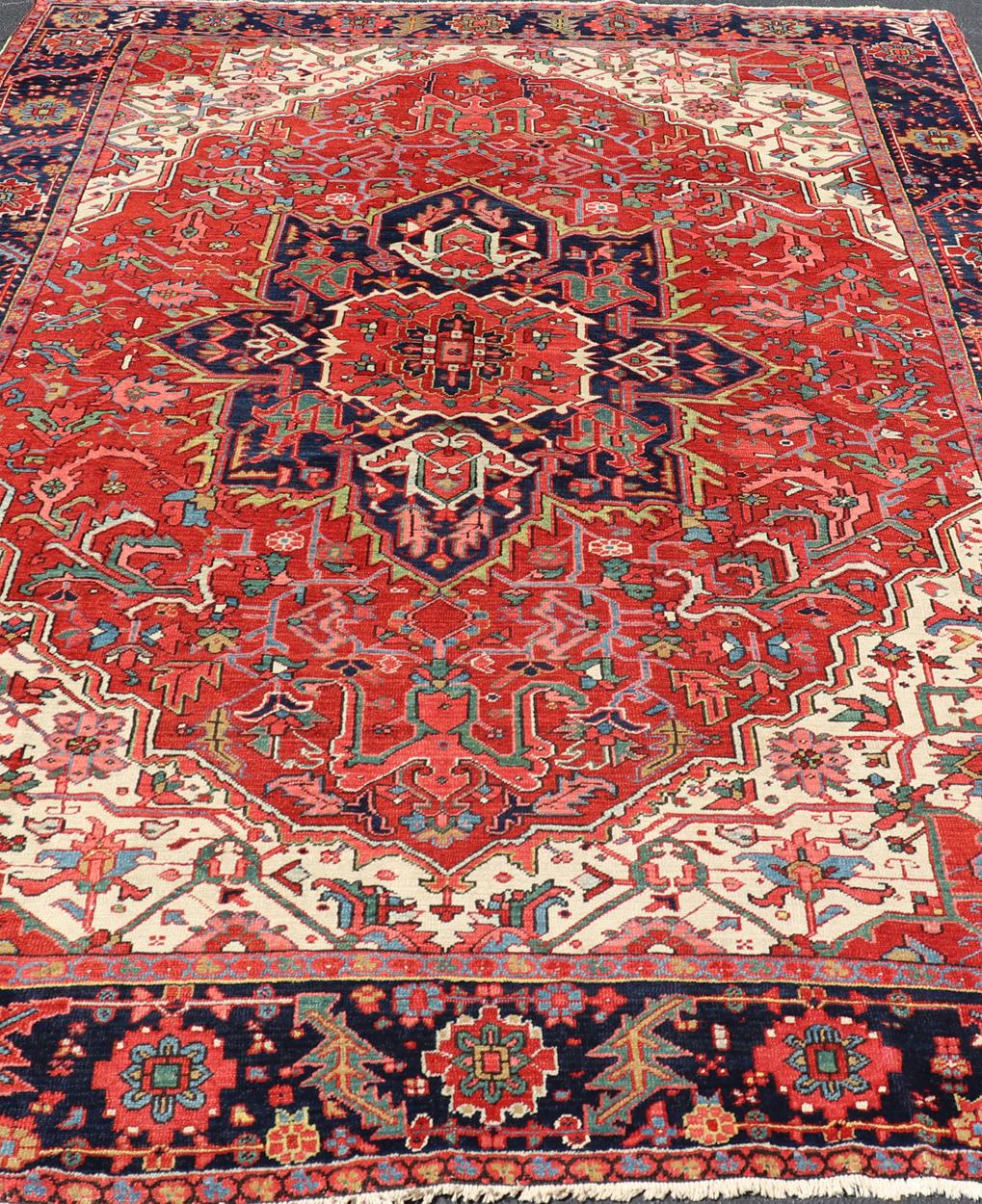 Antique Heriz Carpet with Stylized Central Medallion Set on Tomato Red Field. Keivan Woven Arts / Rug / VR-8759 / country of origin / type: Persian / Serapi, circa early-20th century.
Measures: 8'4 x 11'8.
This beautiful antique Persian Heriz carpet