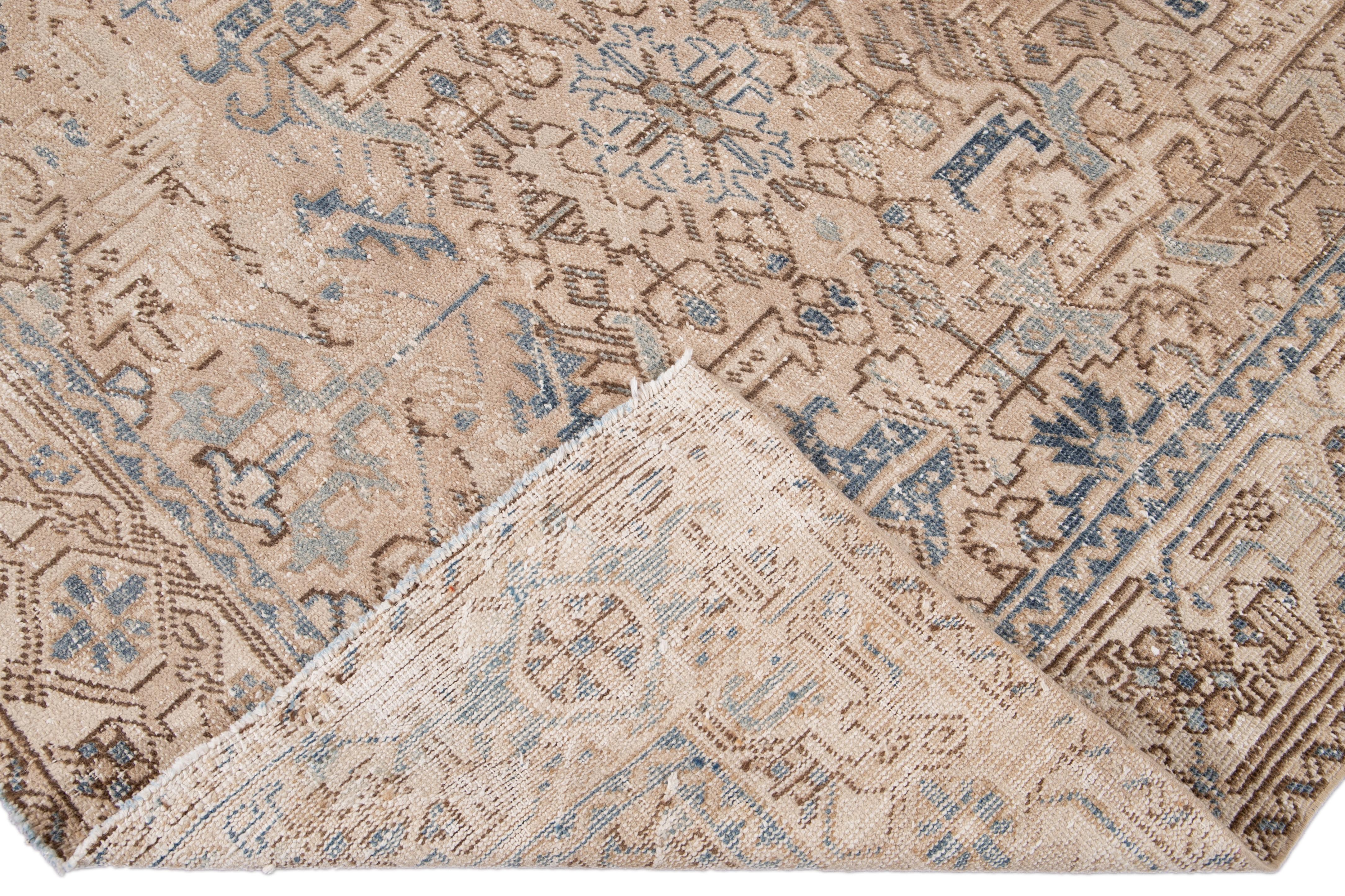 Beautiful antique Persian Heriz hand knotted wool rug with a beige field. This Heriz rug has a blue and brown frame and accents in an all-over gorgeous geometric floral shabby chic design.

This rug measures: 6' x 8'2