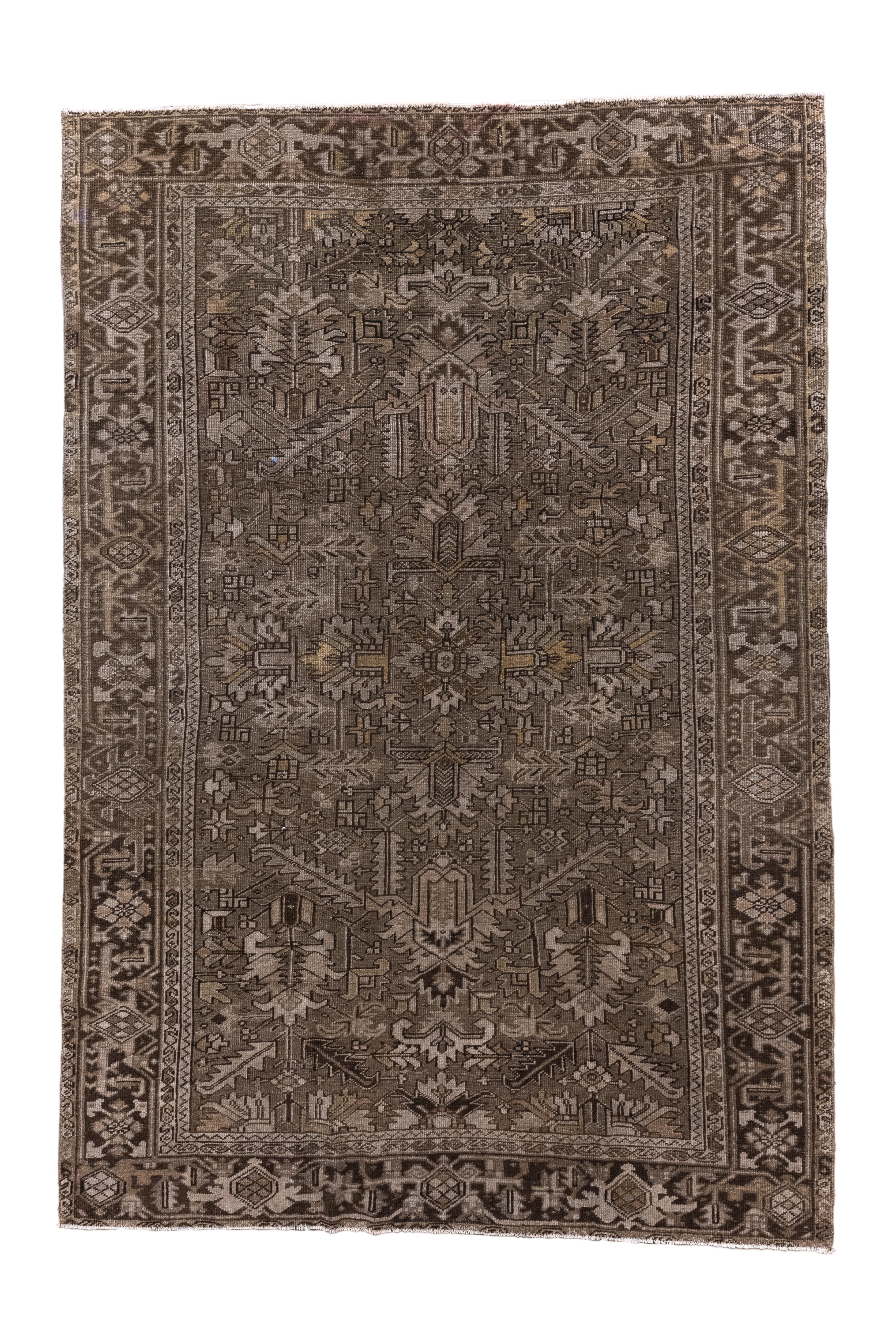 Dieser antike persische Heriz-Teppich, der um 1920 gewebt wurde, zeigt ein wunderschön gedämpftes  Palette von erdigen Brauntönen, Taupe und sanften Neutraltönen, die ihm einen vielseitigen und  schlichte Eleganz. Das zentrale Medaillon und die