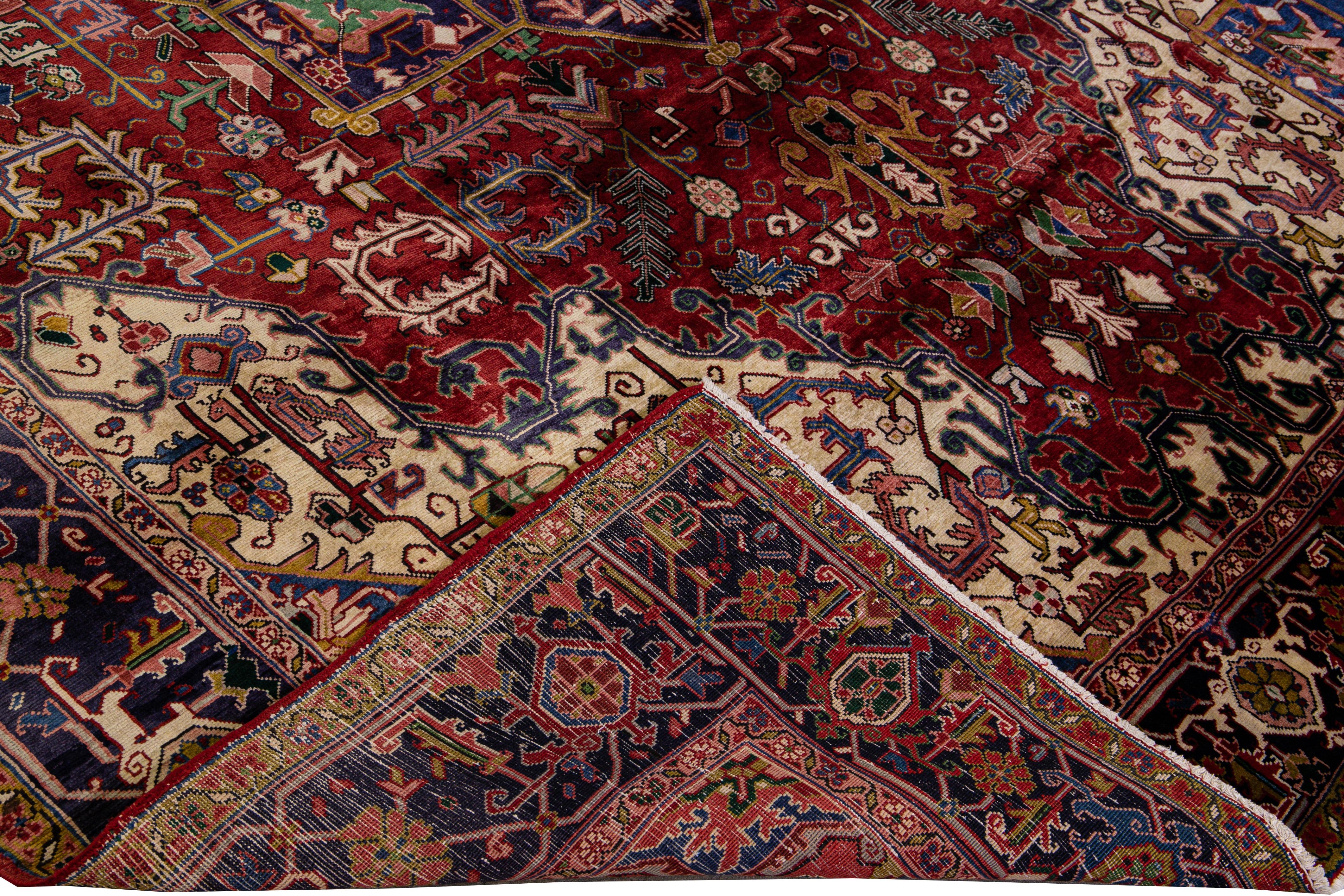 Beautiful vintage fine woven Heriz hand-knotted wool rug with a red field. This Persian rug has a blue-designed frame and multicolor accents in an all-over gorgeous geometric medallion floral motif.

This rug measures: 8'2