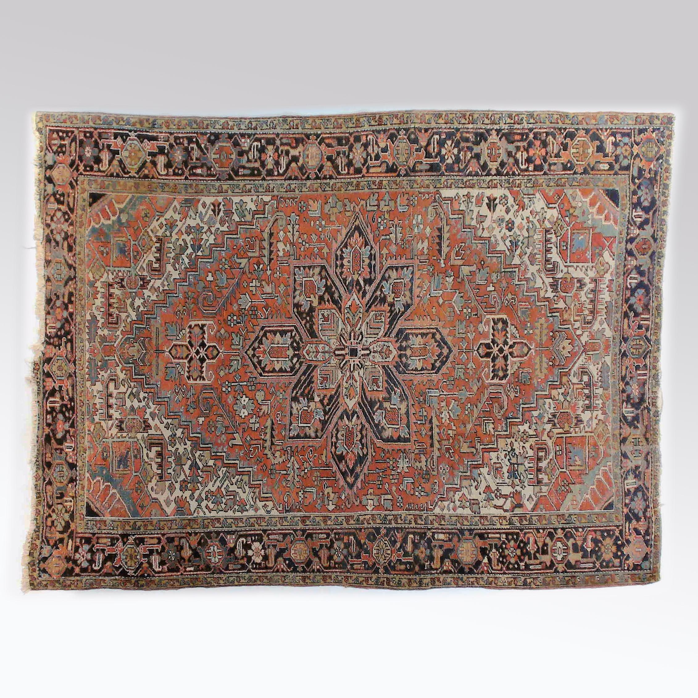 An antique Heriz room size rug offers wool construction with central medallion and foliate elements throughout red ground, c1930

Measures- 131''L x 99.75''W x .5''D.