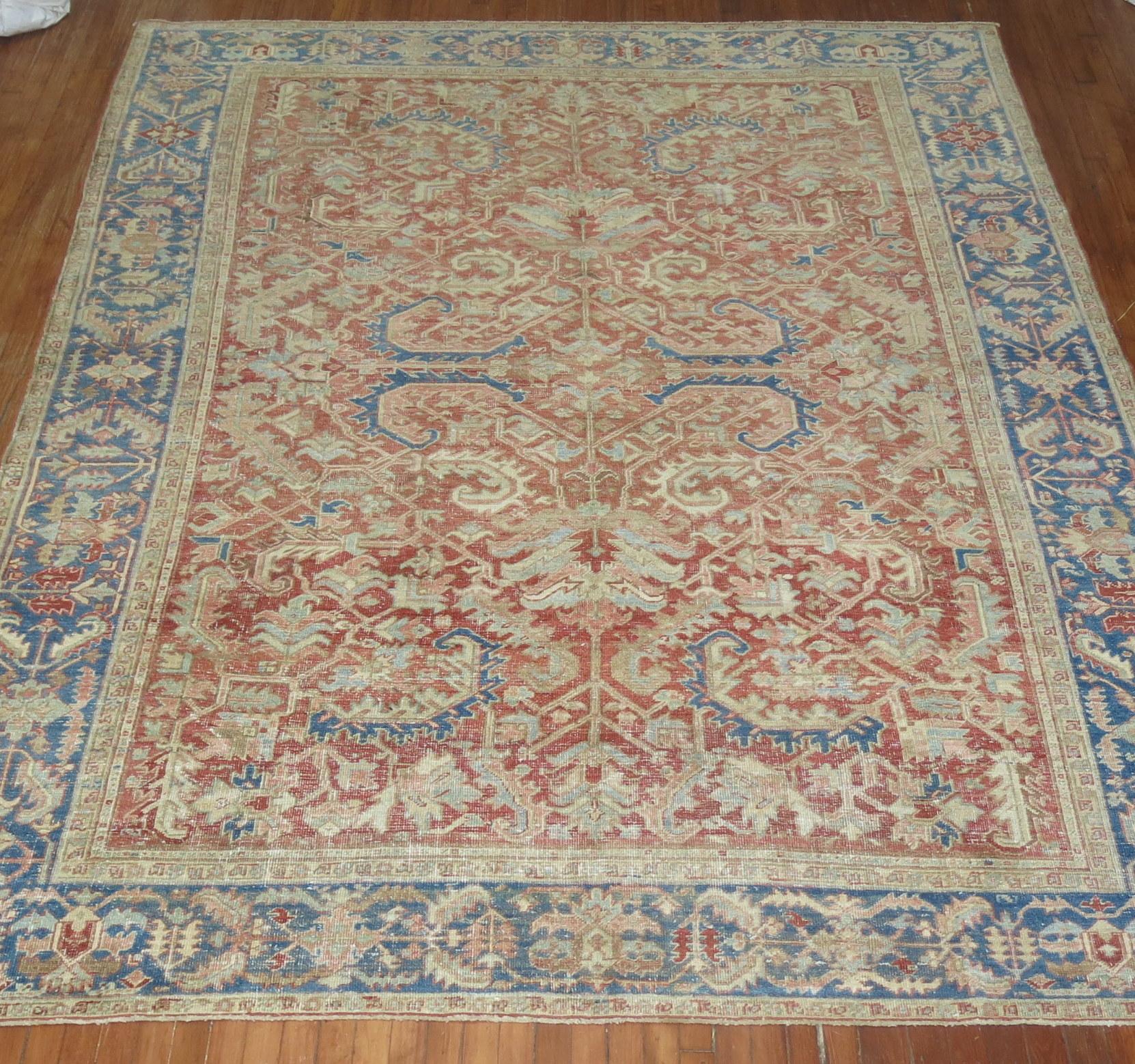This is an early 20th century handwoven decorative room size Persian Heriz rug . Soft red field with soft blue border. Perfect amount of wear, sturdy enough to handle every-day traffic.

With distinctive large-scale motifs and a wide ranging