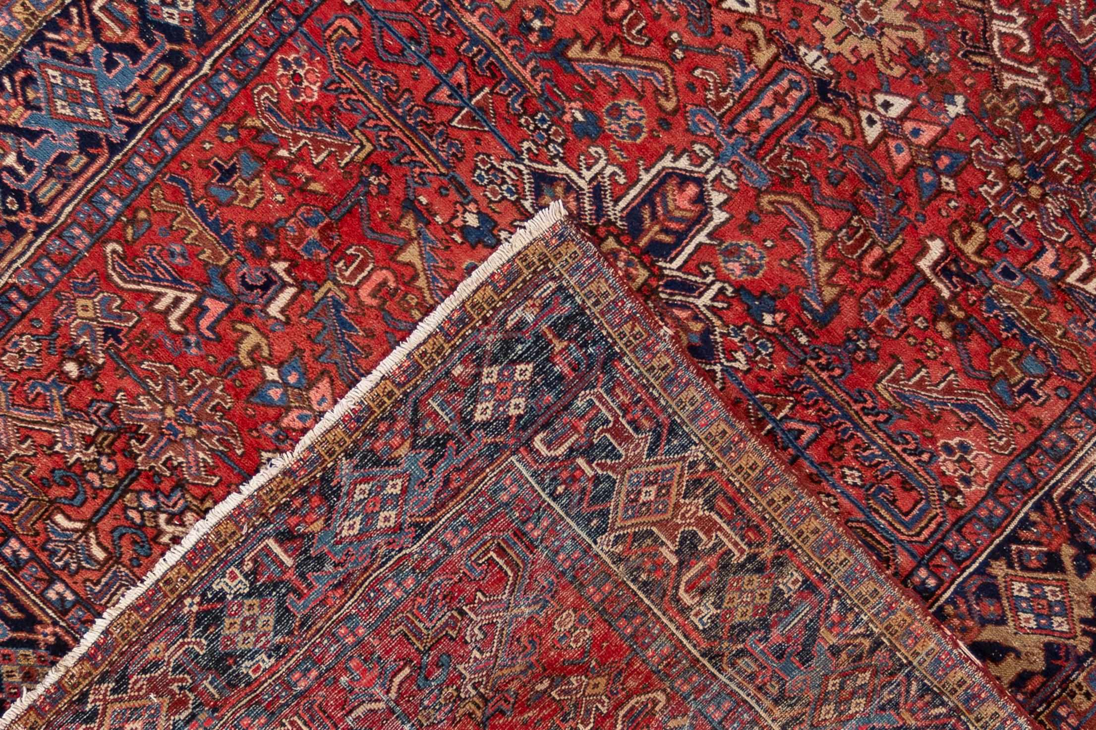 An early 20th century Square antique Heriz rug with an all over red motif and centre medallion. This rug measures at 7'7