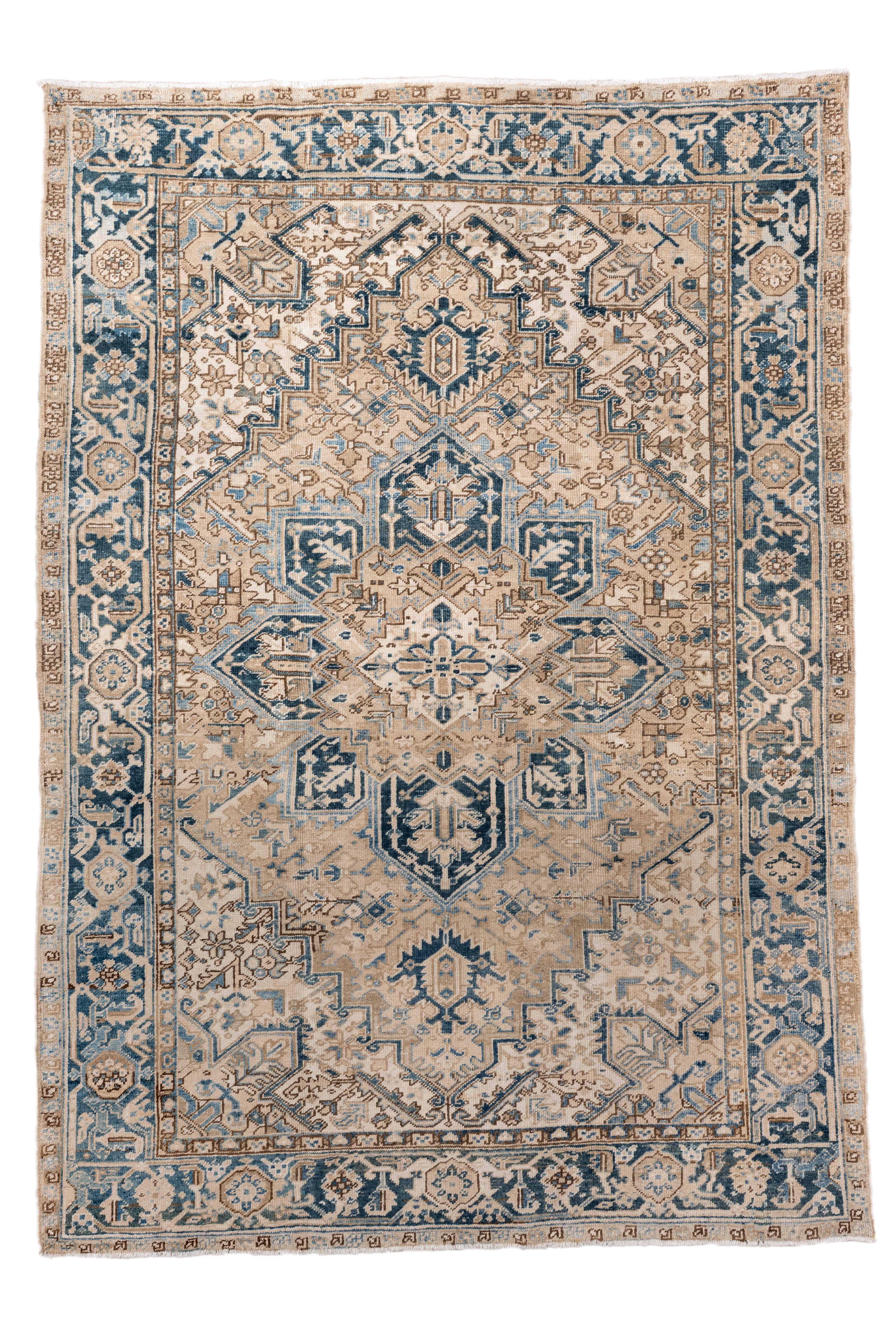 Ein atemberaubender antiker Heriz-Teppich mit einer seltenen und begehrten Farbpalette aus zartem Denim-Blau, Elfenbein und warmen Sandtönen. Das zentrale Medaillon schwebt auf einem dezent abgewetzten beigen Feld, umgeben von abgestuften