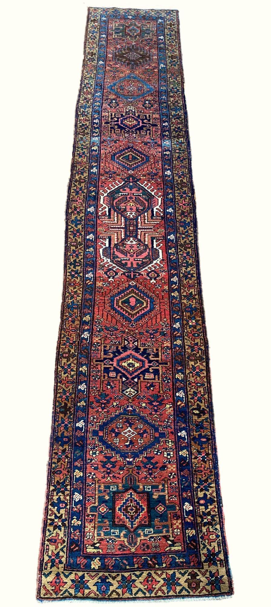Ein fabelhafter antiker Heriz-Läufer, handgewebt um 1910. Das Design zeigt zahlreiche geometrische Medaillons auf einem Terrakotta-Feld und einer Kamel-Bordüre. Hübsche Sekundärfarben wie Rosa, Hellblau und Gold.
Größe: 4,70m x 0,87m (15ft 5in x 2ft