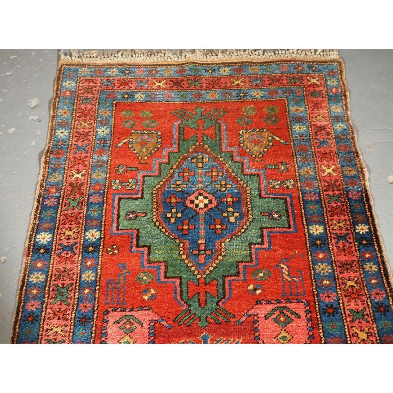 Antique Persian Heriz rug of good size, with traditional medallion design.

The runner has a traditional Heriz medallion design on a terracotta red ground, the medallions are in shades of indigo blue, green and pink. The border is of a design