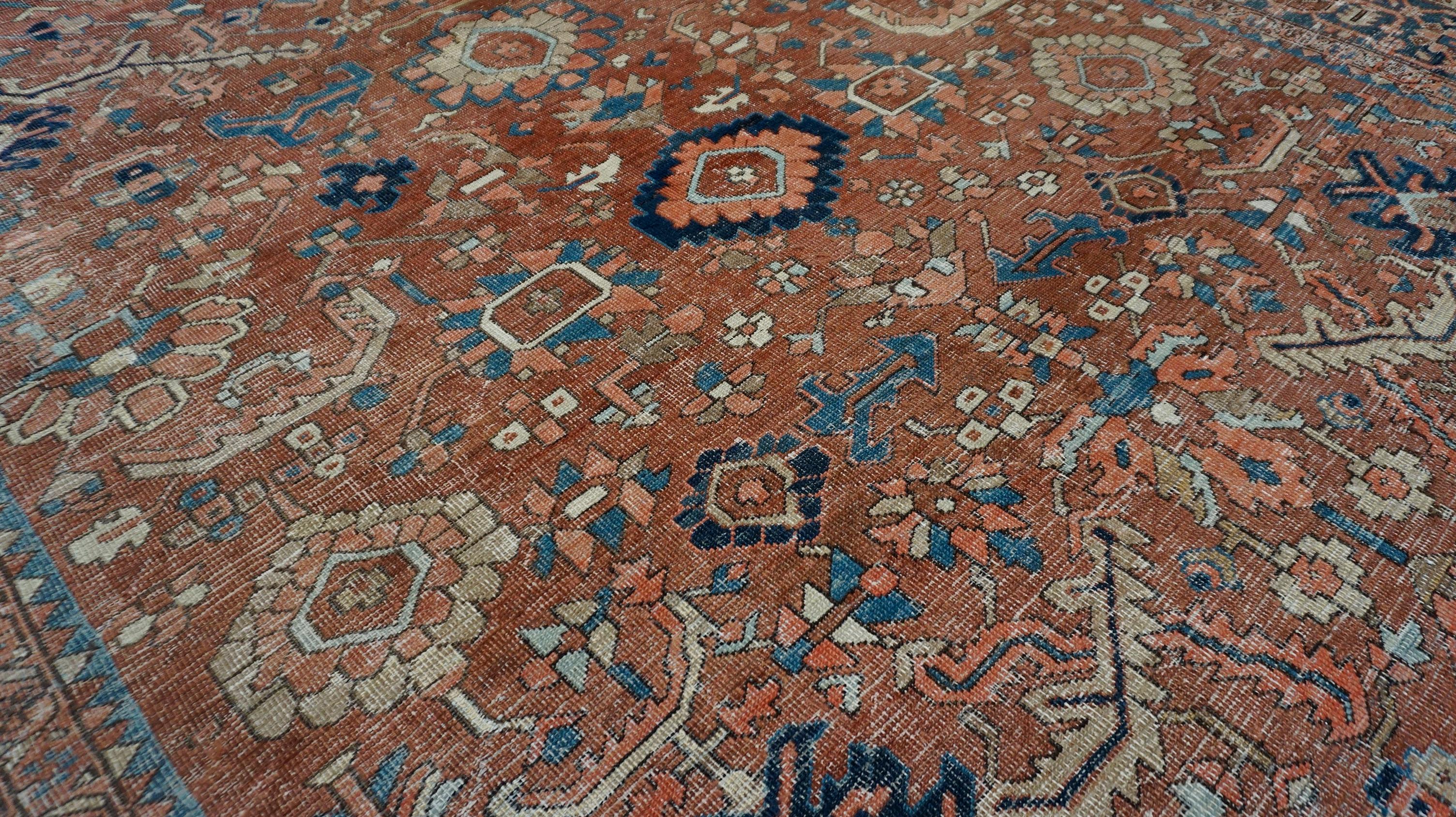 This striking antique Heriz rug is a true representation of the rugged beauty and enduring craftsmanship of the Heriz weaving tradition. Hand-knotted in the late 19th to early 20th century, this piece showcases the distinctive geometric medallion