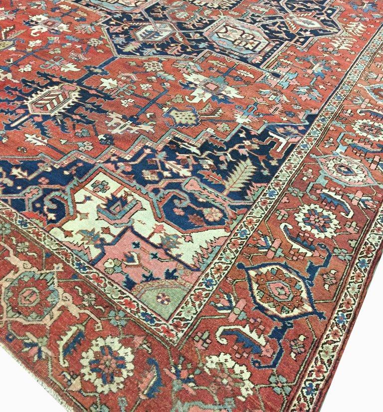Ancien tapis Heriz Serapi, mesure 9'8 X 13'4. Cet ancien tapis Persan Heriz représente un joli médaillon symétrique tissé en bleu, rouge et crème. Le champ de mandarine foncé est sécurisé par des écoinçons bleu persan avec de magnifiques motifs