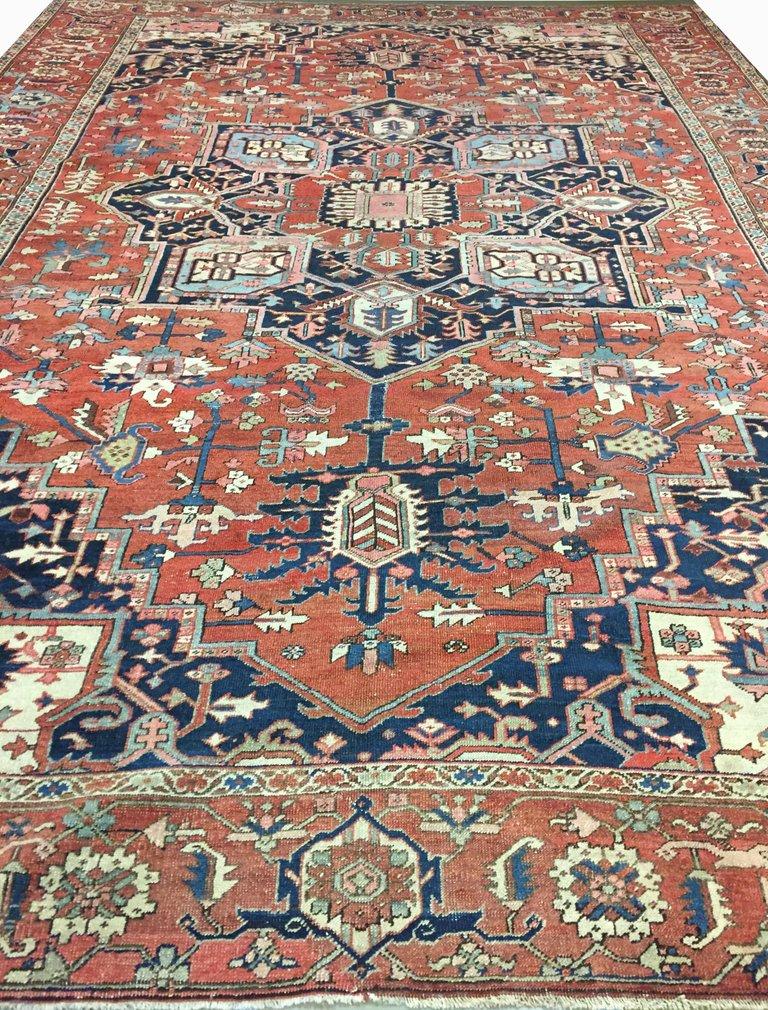 Antique Heriz Serapi rug, circa 1880. This antique Persian Heriz rug depicts a lovely symmetrical medallion woven in blues reds and creams. The dark tangerine field is secured by Persian blue corner spandrels with gorgeous floral patterns.