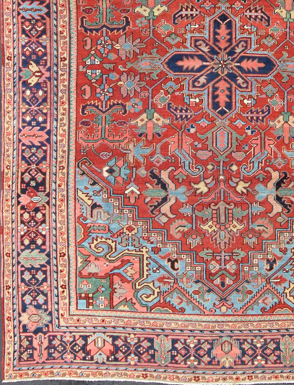 Brilliante Tapis ancien Heriz avec médaillon central et design géométrique.  Fabriqué au début du XXe siècle en Iran, ce charmant Heriz antique présente un design ouvert et un éventail de couleurs gaies. Entourant son petit médaillon central, cette