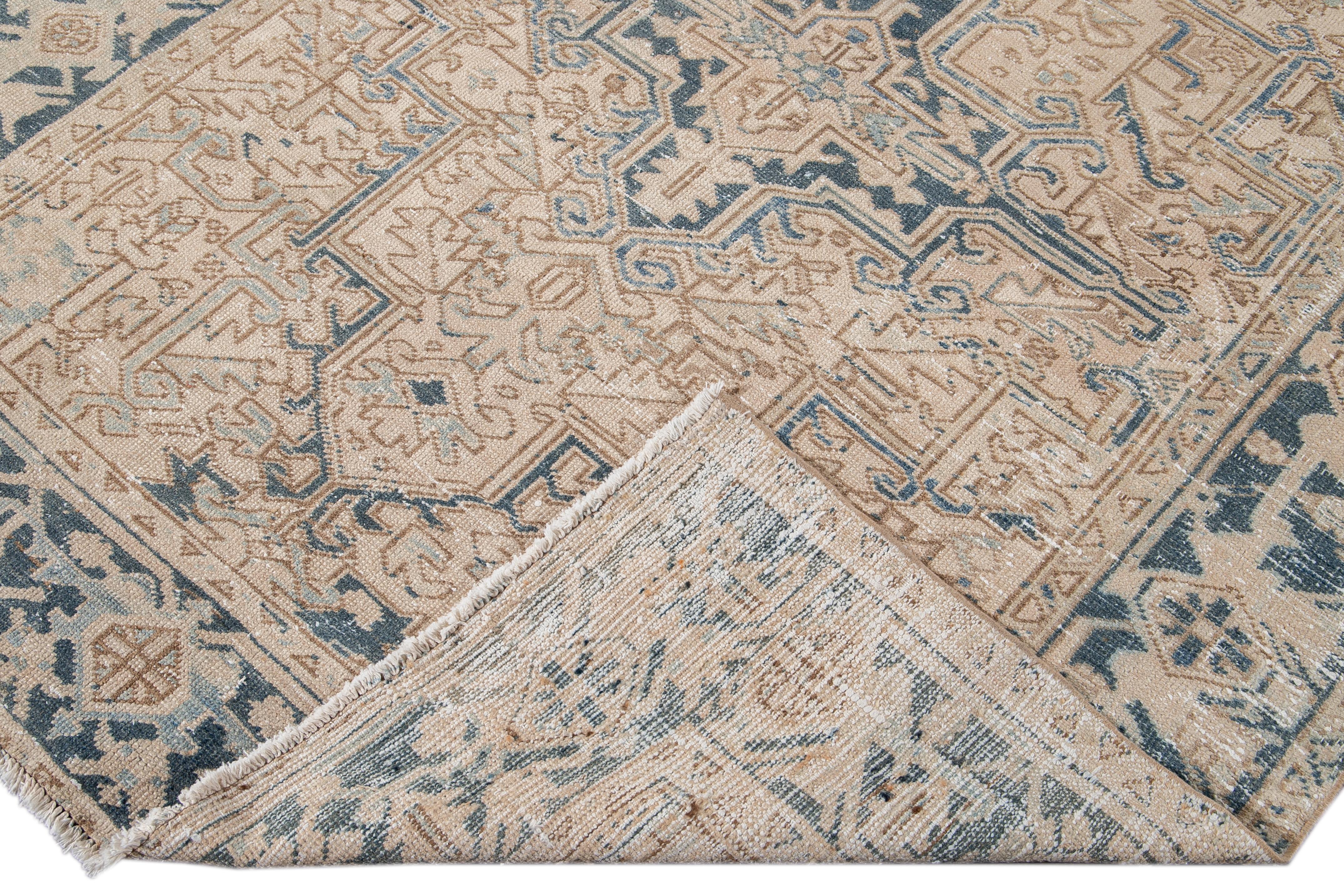 Beautiful antique Persian Heriz hand-knotted wool rug with a beige field. This Heriz rug has a blue frame and accents in an all-over gorgeous geometric floral shabby chic design.

This rug measures: 6'3