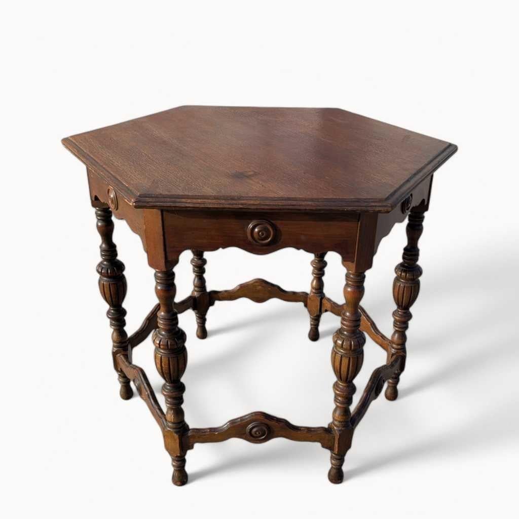 An elegant Early 20th Century accent table crafted in dark stained wood with a rich, patinated finish, featuring a distinctive hexagonal top, ornate turned legs, and a subtle scalloped apron. This piece beautifully embodies the ornate craftsmanship