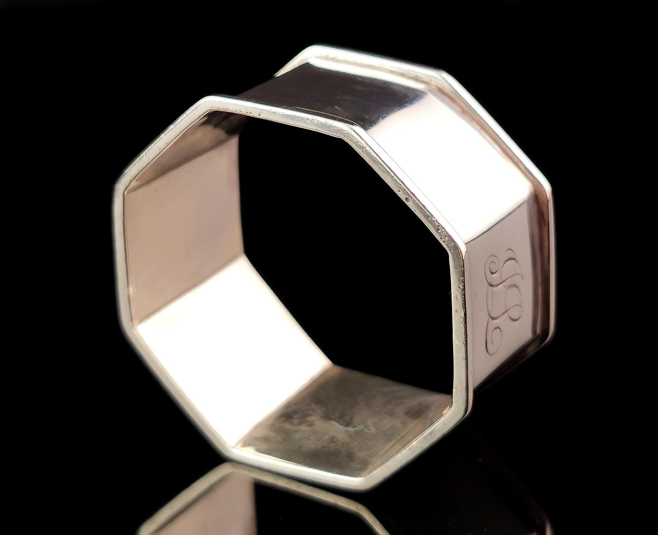 An attractive antique sterling silver napkin ring.

It is a sleek high polished napkin ring with a hexagonal shape.

It has a slight raised rim and a monogram to the front.

The monogram has been hand engraved and reads JL.

It is fully hallmarked