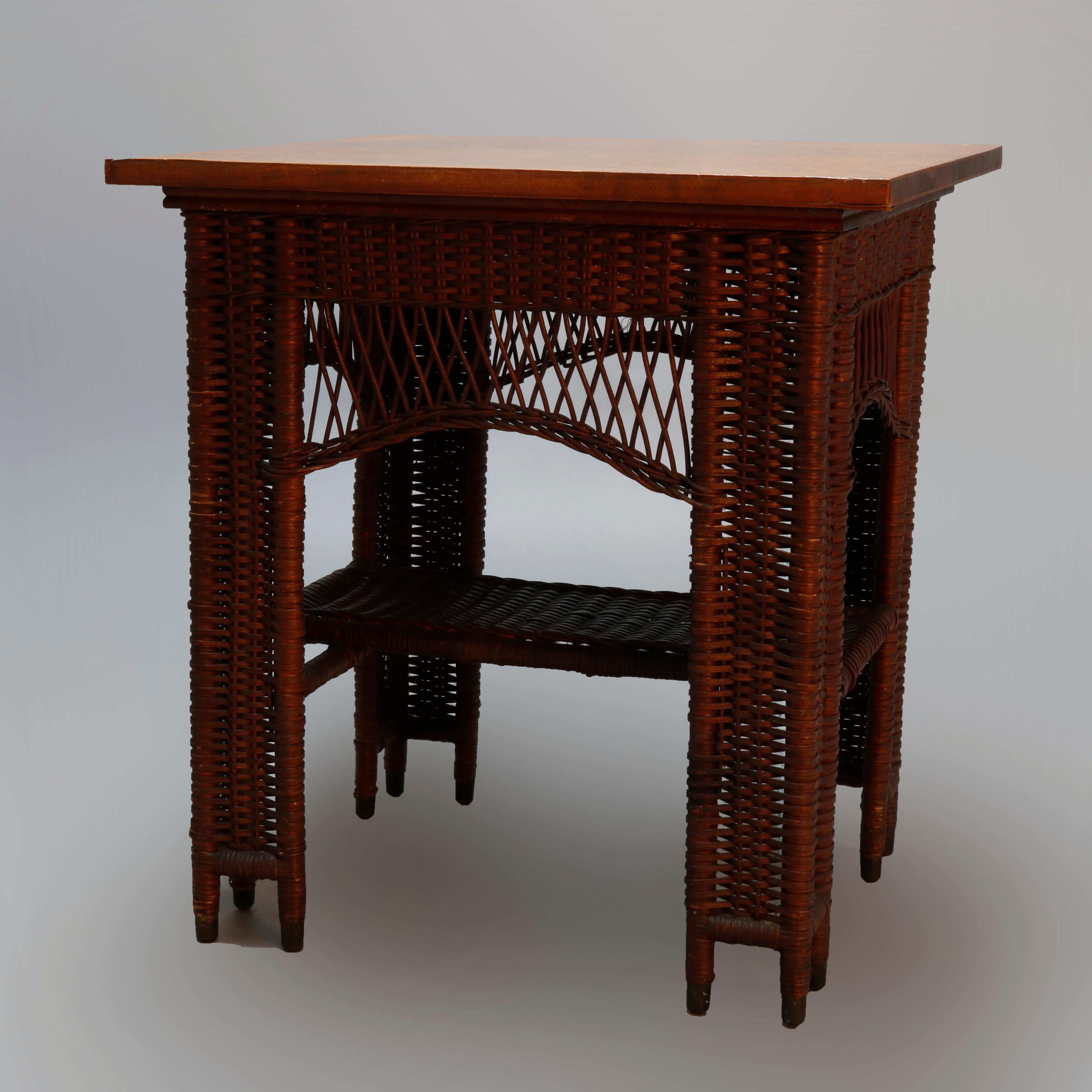 Antique Arts & Crafts lamp table by Heywood Wakefield offers oak frame with wicker panels and shaped skirt with lower display shelf, without label, circa 1910

Measures: 30