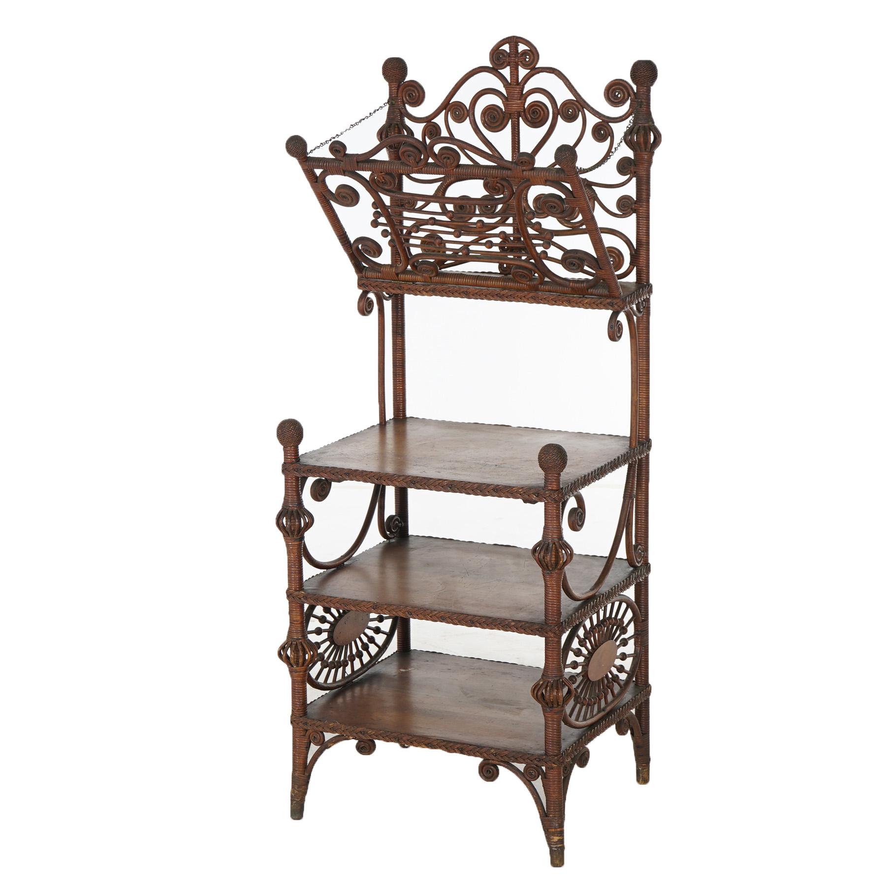 An antique Heywood Wakefield magazine stand offers wicker stick and ball construction with scroll form frame, upper portfolio, and three shelves, c1890

Measures - 48.25