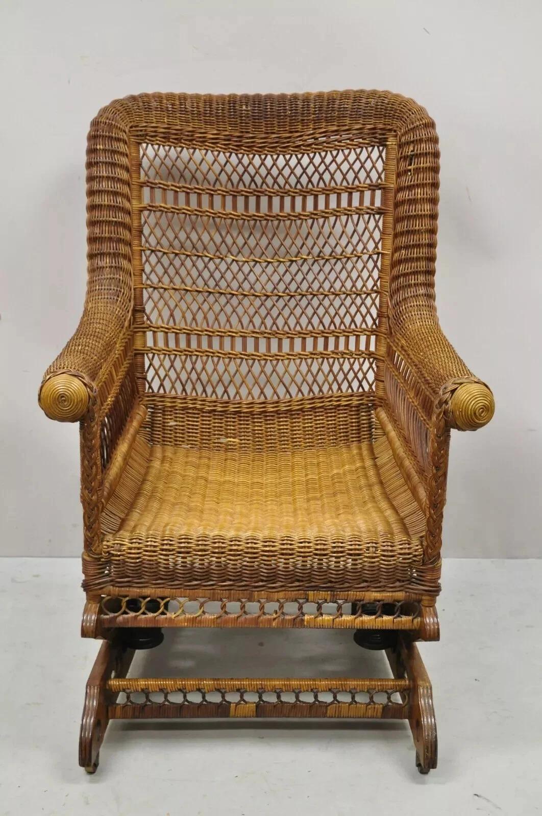 Antica sedia a dondolo a piattaforma vittoriana in vimini Heywood Wakefield. L'articolo presenta una base a dondolo con piattaforma in legno intagliato e rotelle, struttura in vimini intrecciato, braccioli arrotolati, resti dell'etichetta originale,