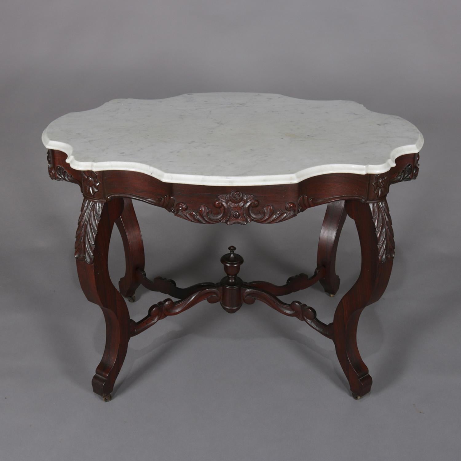 Antique high Victorian centre table features shaped and bevelled marble turtle top seated carved walnut base with shaped skirt having central foliate decoration and raised on cabriole legs with carved acanthus knees and scroll from stretchers with