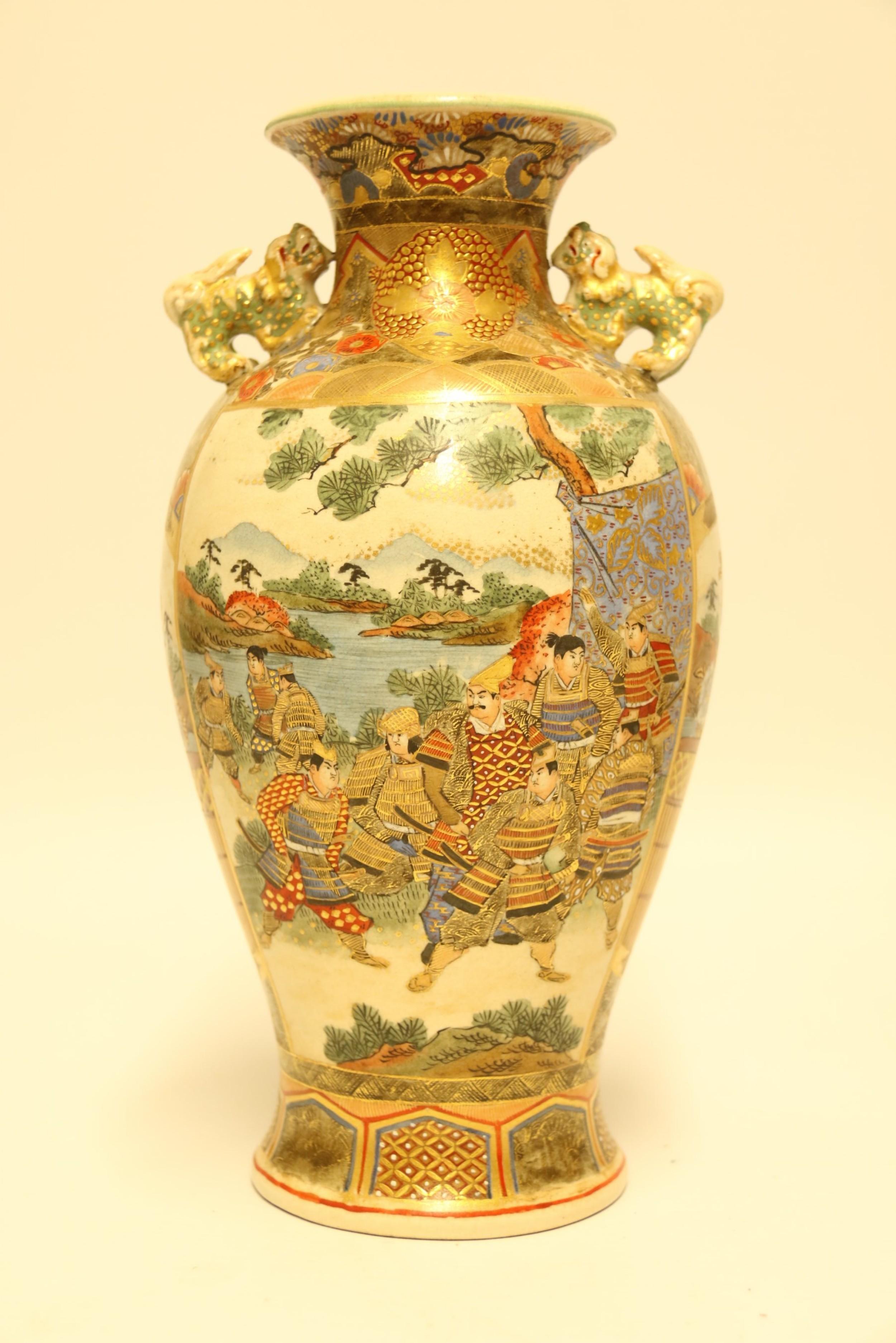 A decorative pair of Satsuma vases made in Japan, circa 1910. 
The vases are decorated with geometric panels in rich raised gilt work, enamel and floral designs with central panels front and back depicting figures in traditional costume of the