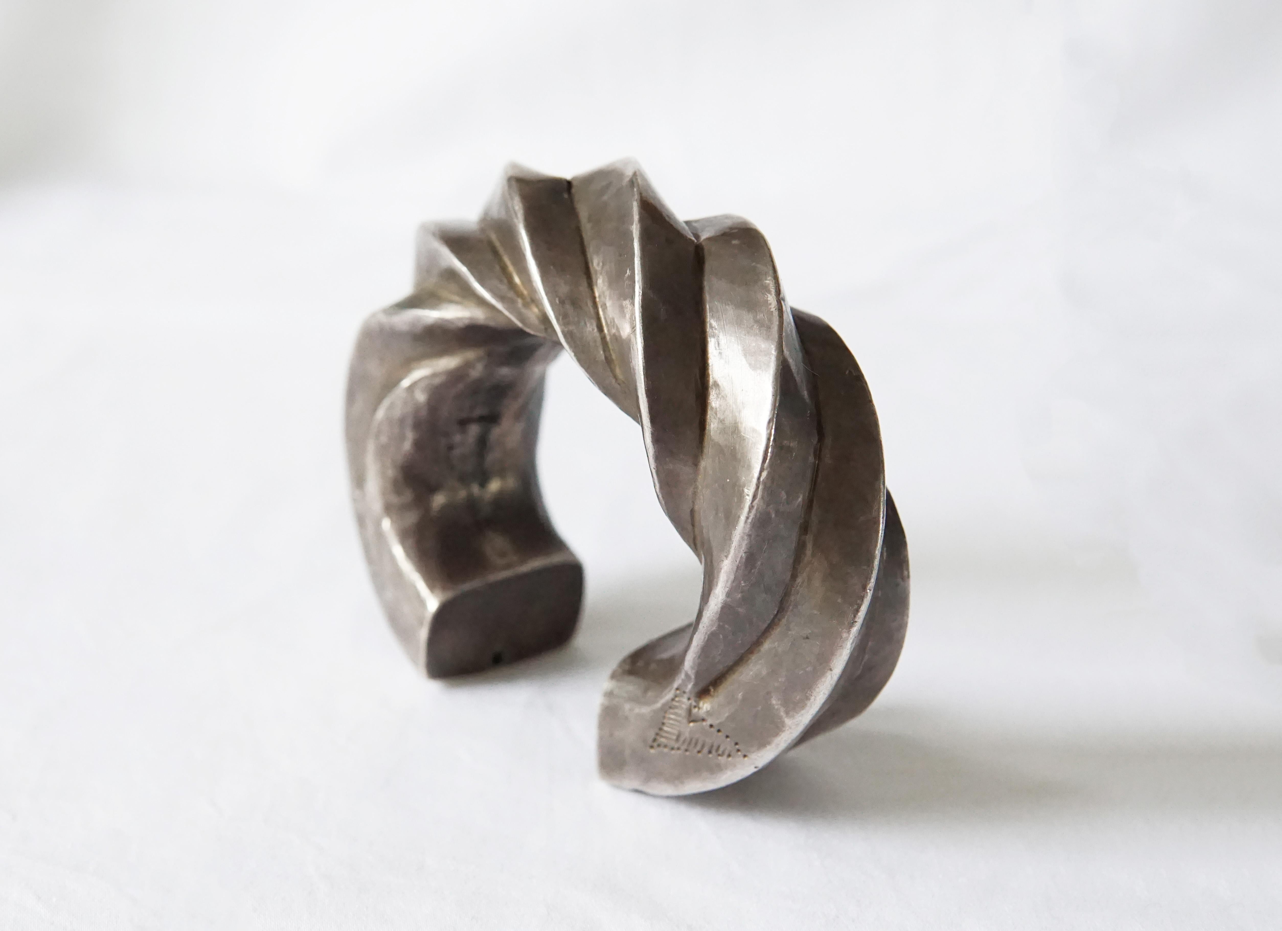 This unique tribal cuff bracelet originates from the Karen Hill Tribe of Northern Thailand via tribal silversmith techniques that have been handed down through generations. There are subtle hand stamped tribal patterns on both sides and both ends.