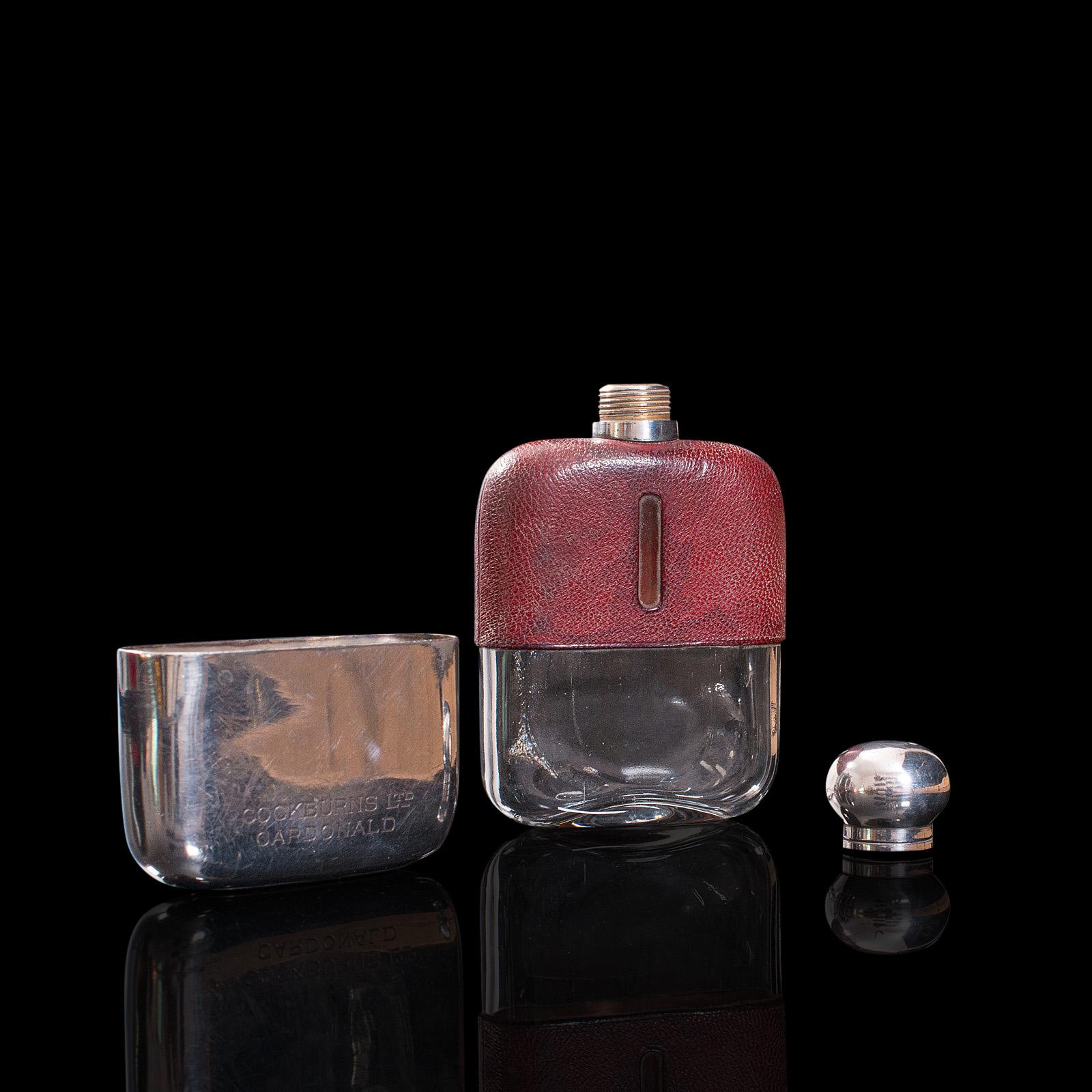 This is an antique hip flask. An English, leather bound, glass and silver plated retirement or celebration gift, dating to the early 20th century, circa 1920.

Tactile in form and of usable pocket size at 3/16th of a pint
Displaying a desirable