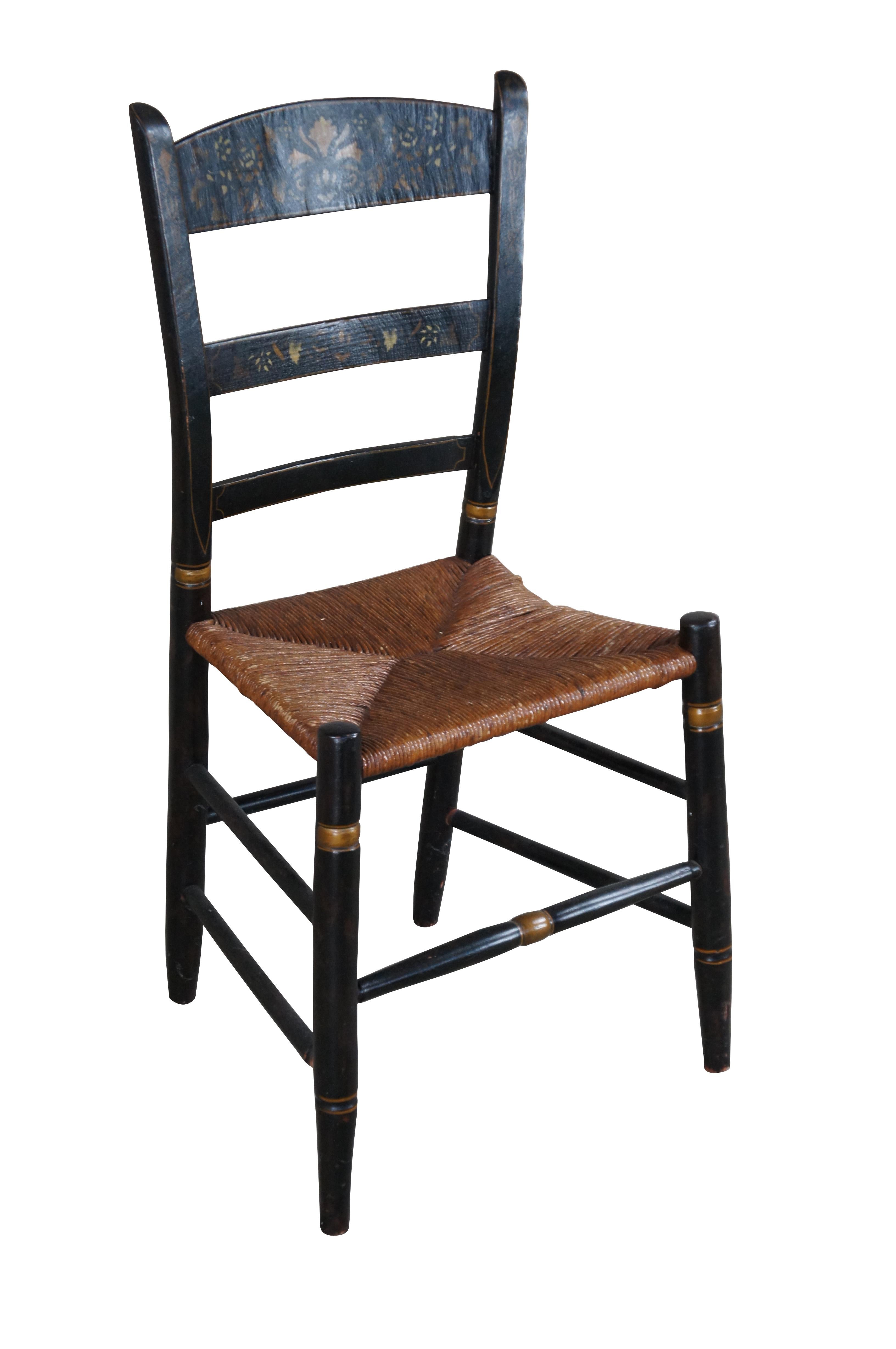 An antique Hitchcock stenciled back farmhouse chair.  Feature a black painted frame with gold trim and a fall harvest scene along the back.  Seat is woven with rush.

Dimensions:
16 1/2