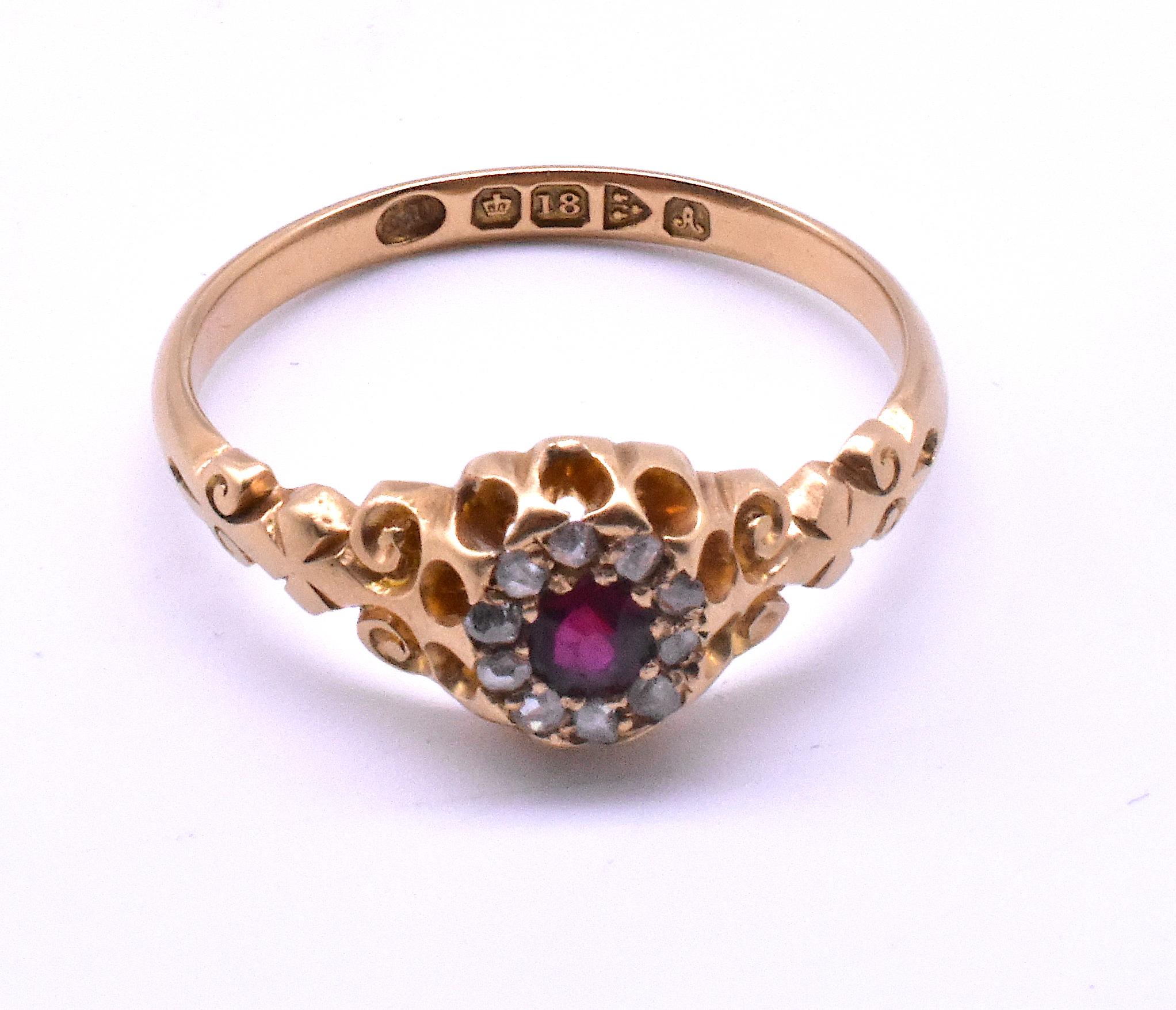 18K Late Victorian cluster ring with 10 rose cut diamonds surrounding a large deeply chromatic red ruby at its center (also known as a coronet setting). Because it is hallmarked Chester for the year 1901 and 18K gold, its age and gold content are