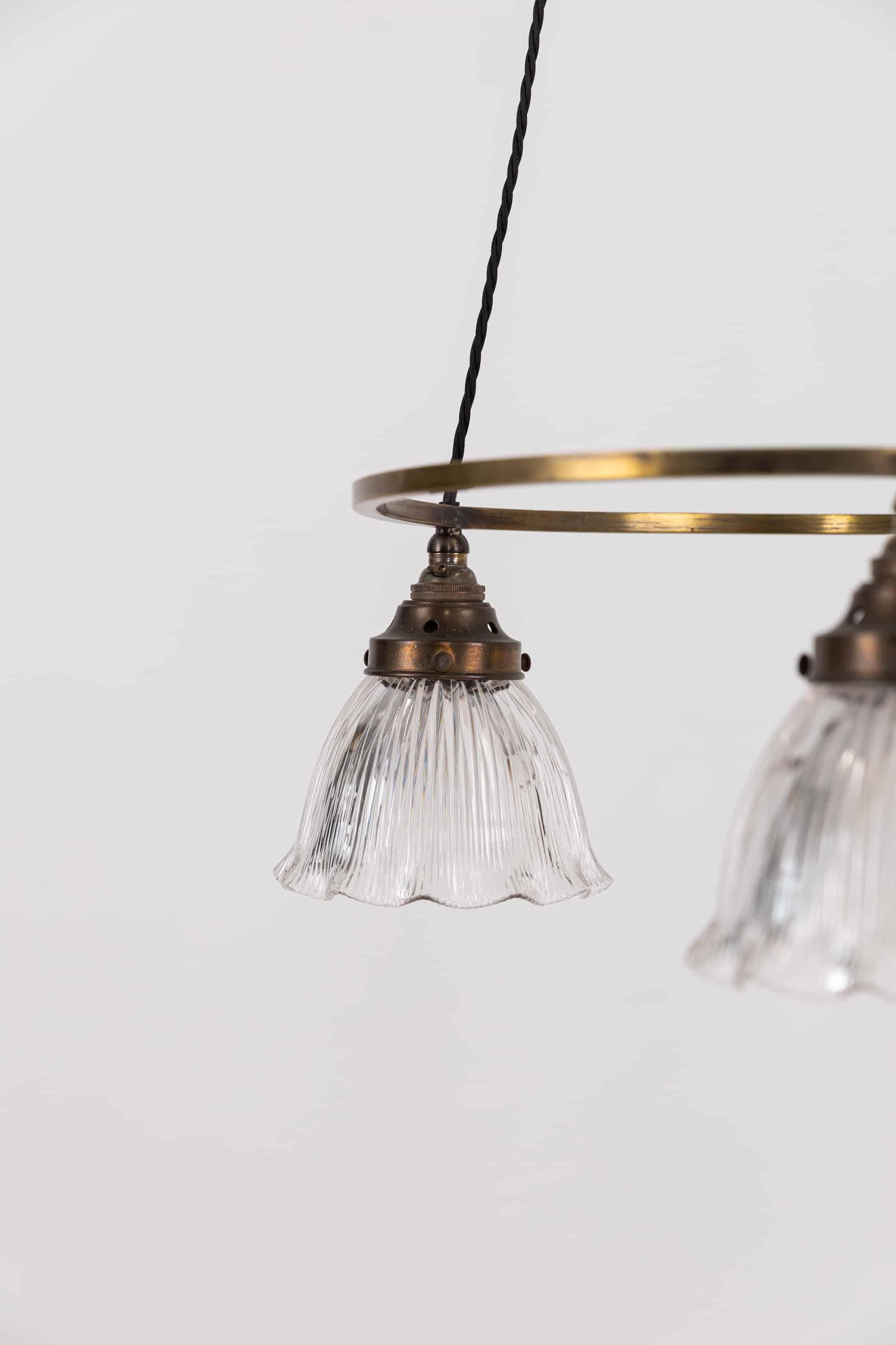 A very elegantly formed cluster light by in England by Holophane. circa.1920

Comprising of brass ring supporting three prismatic glass Holophane 'Stiletto' shades. Super decorative ceiling plate allows the flex to support the weight below and