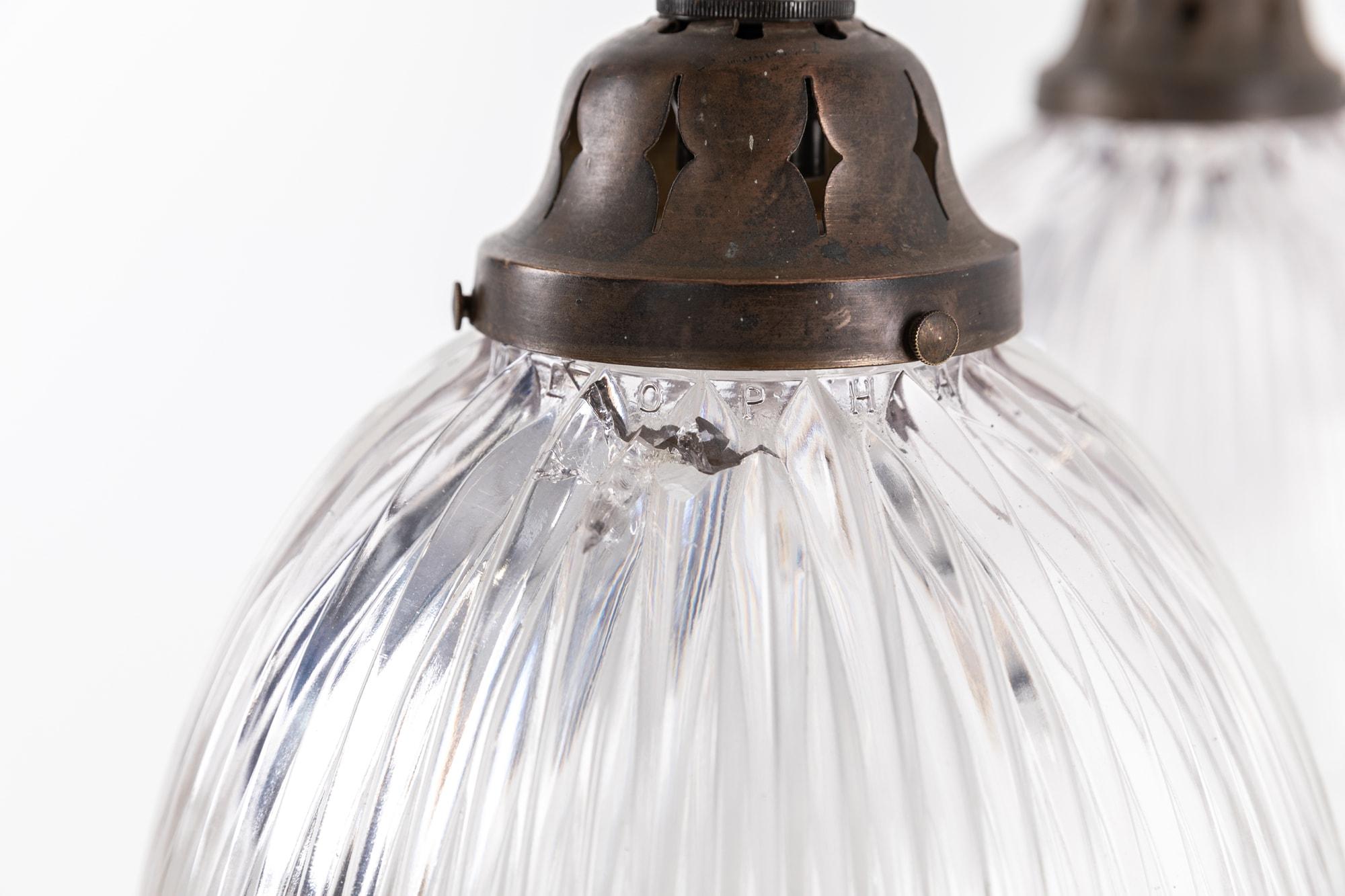 

Elegantly formed prismatic glass 'Stiletto' pendant lights made in England by Holophane. c.1920

Clear scalloped designed glass with Holophane stamp to the rim of the shade and original aged brass galleries. Price is per lamp.

Rewired with 1m of