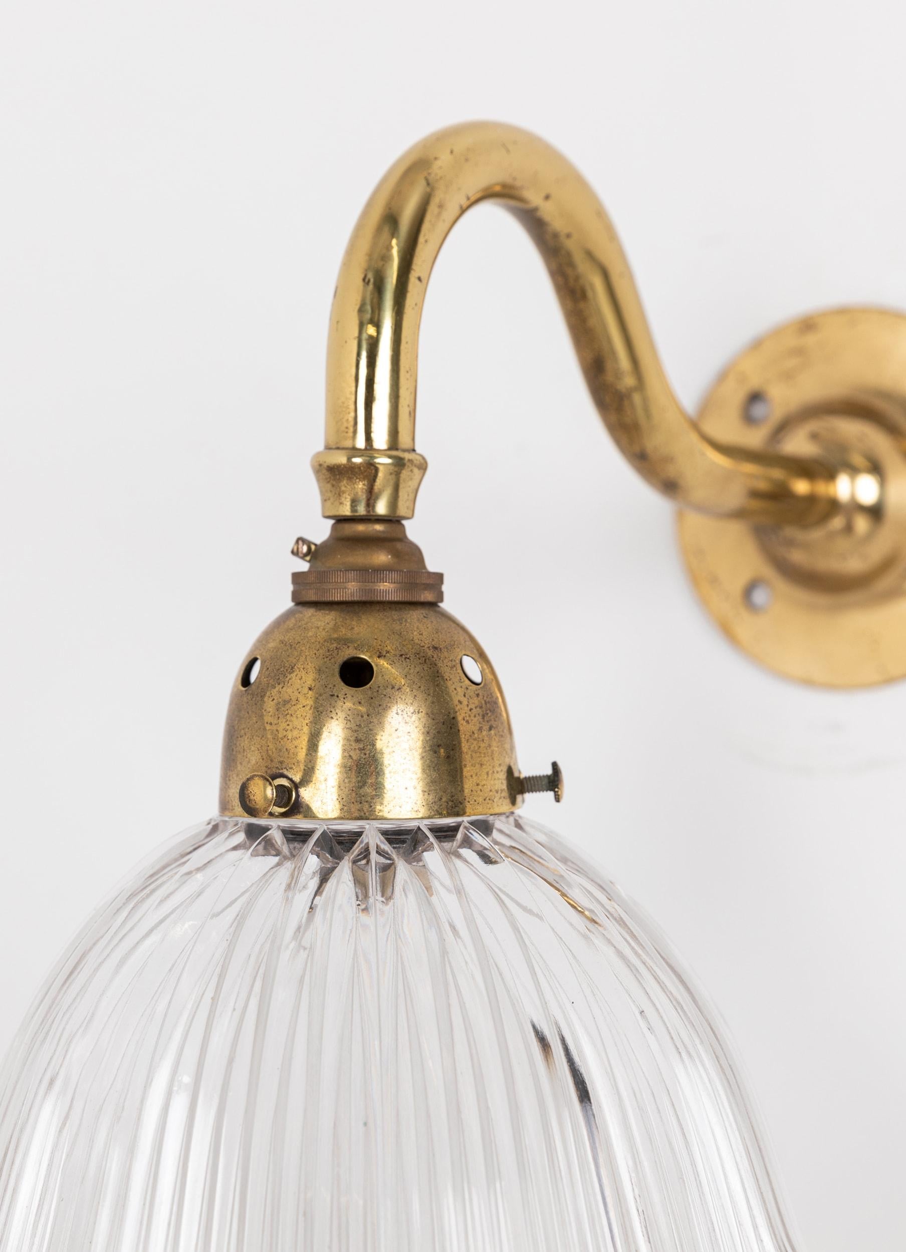 A superb wall mounted light made in England by Holophane. c.1920

The prismatic glass frilly 'Stiletto' shade made by Holophane, stamped to rim, and simple brass swan neck wall bracket.
