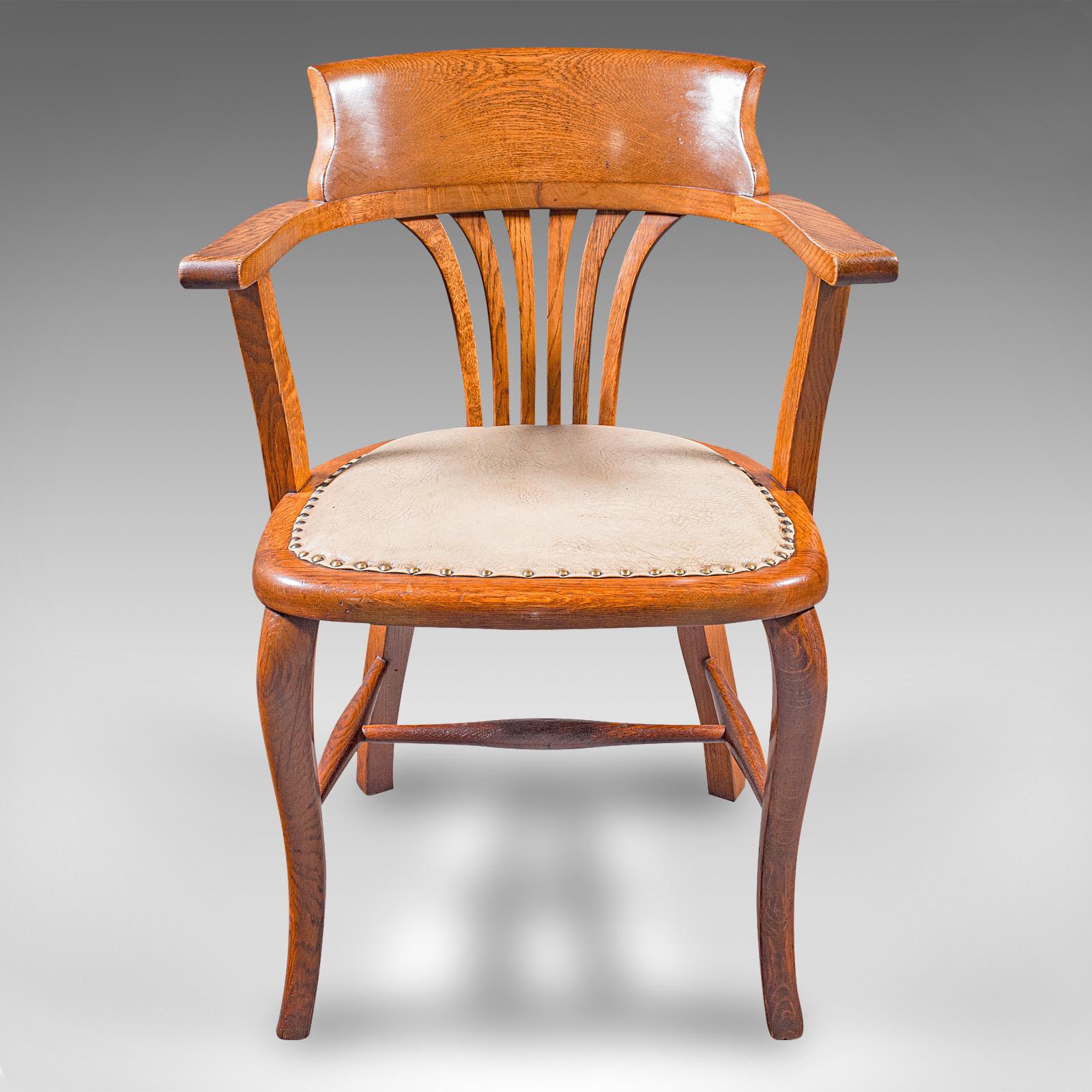 
This is an antique office desk chair. An English, oak drawing room elbow seat, dating to the Edwardian period, circa 1910.

Inviting desk chair, ideal for the drawing room or home office
Displaying a desirable aged patina and in good order
Select