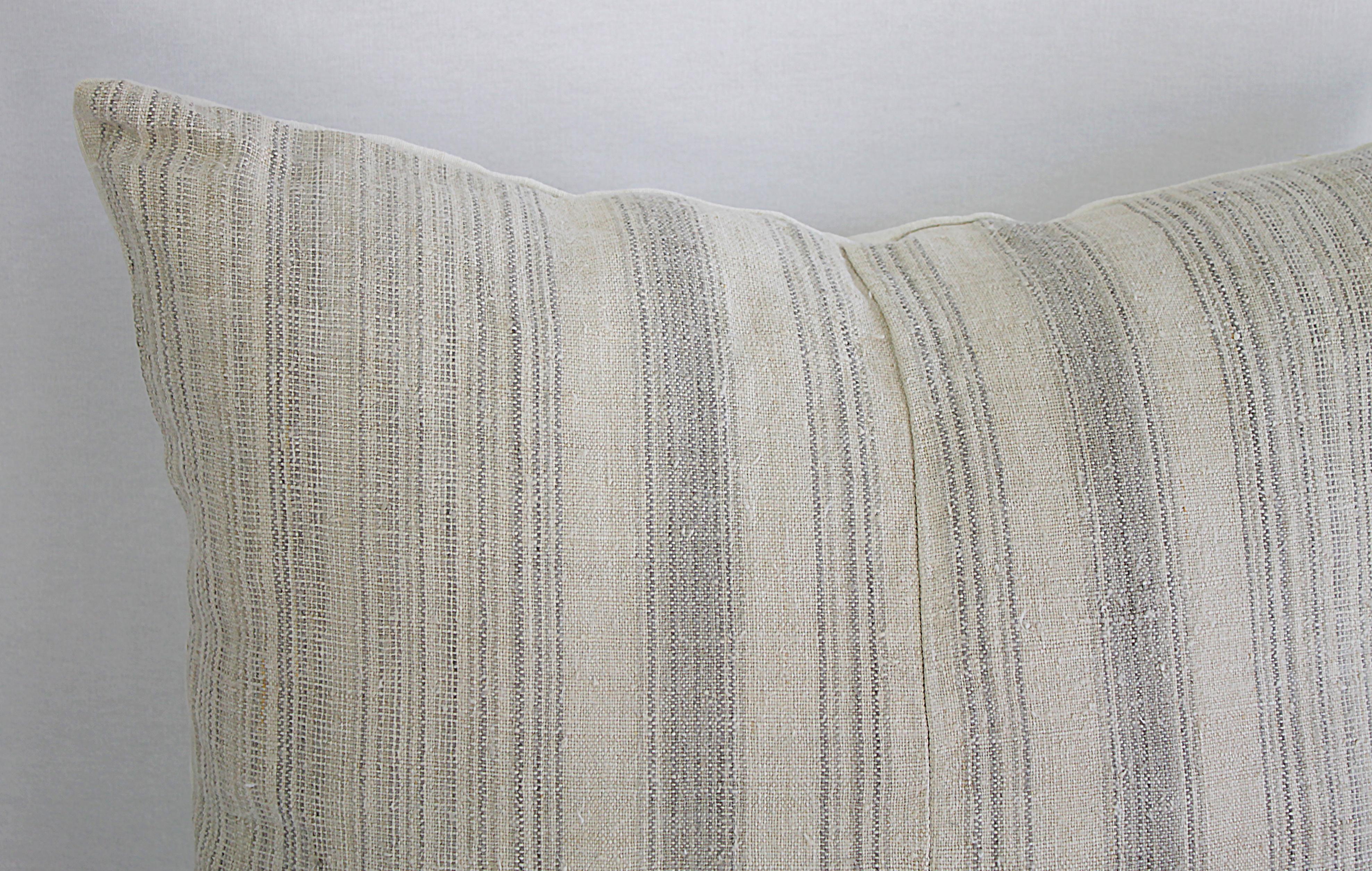 Antique homespun linen and striped grain sack pillow.
Light grey and creamy white striped grain sack front, the backside is finished in a off white natural French linen. The front of the pillows are made from 19th century homespun linen, and the
