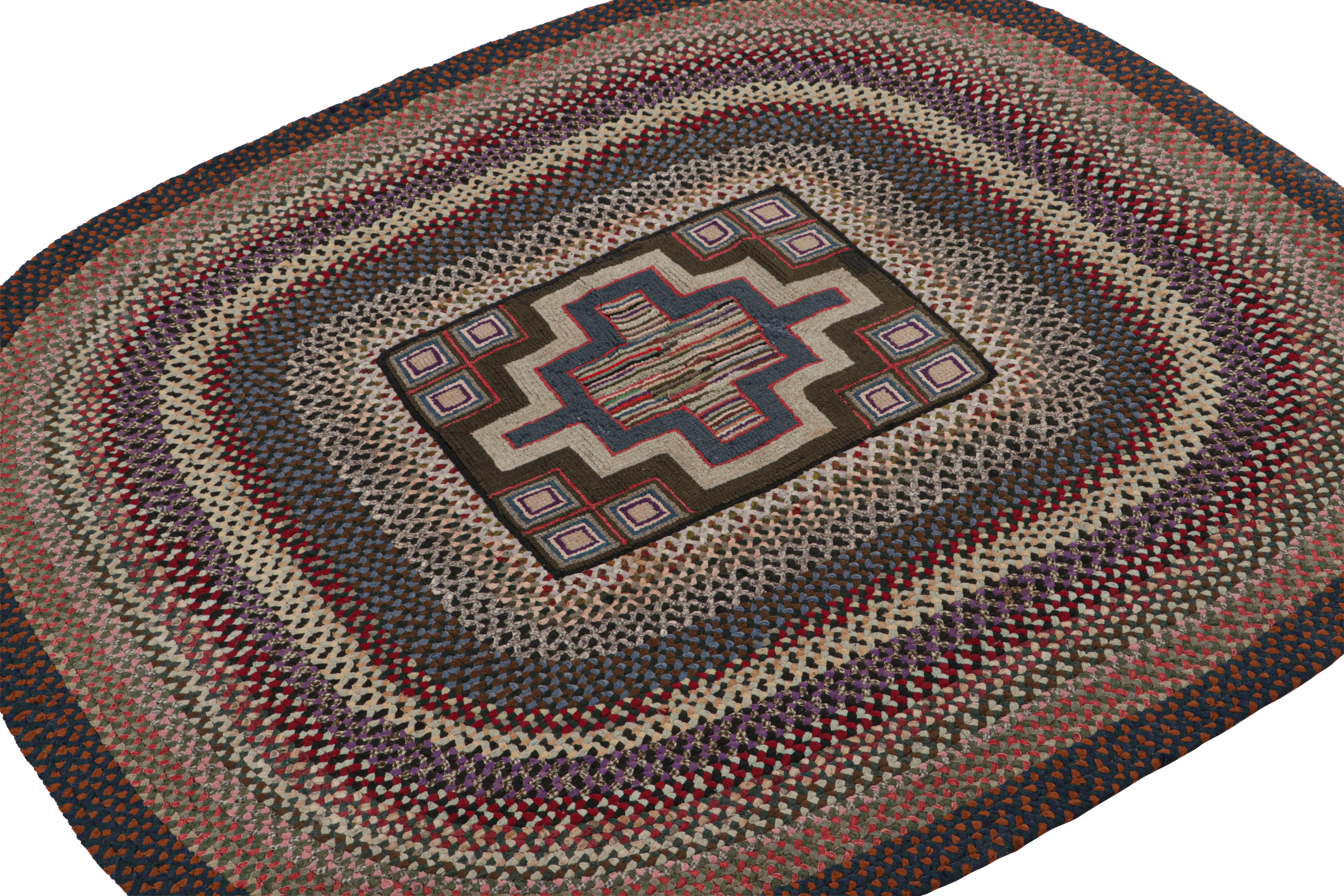 A rare 4x5 antique hooked oval rug of United States’ provenance, handmade in wool and fabric, circa 1920-1930, featuring polychromatic braided stripes and geometric patterns. 

On the Design: 

This collectible piece enjoys layers of geometric